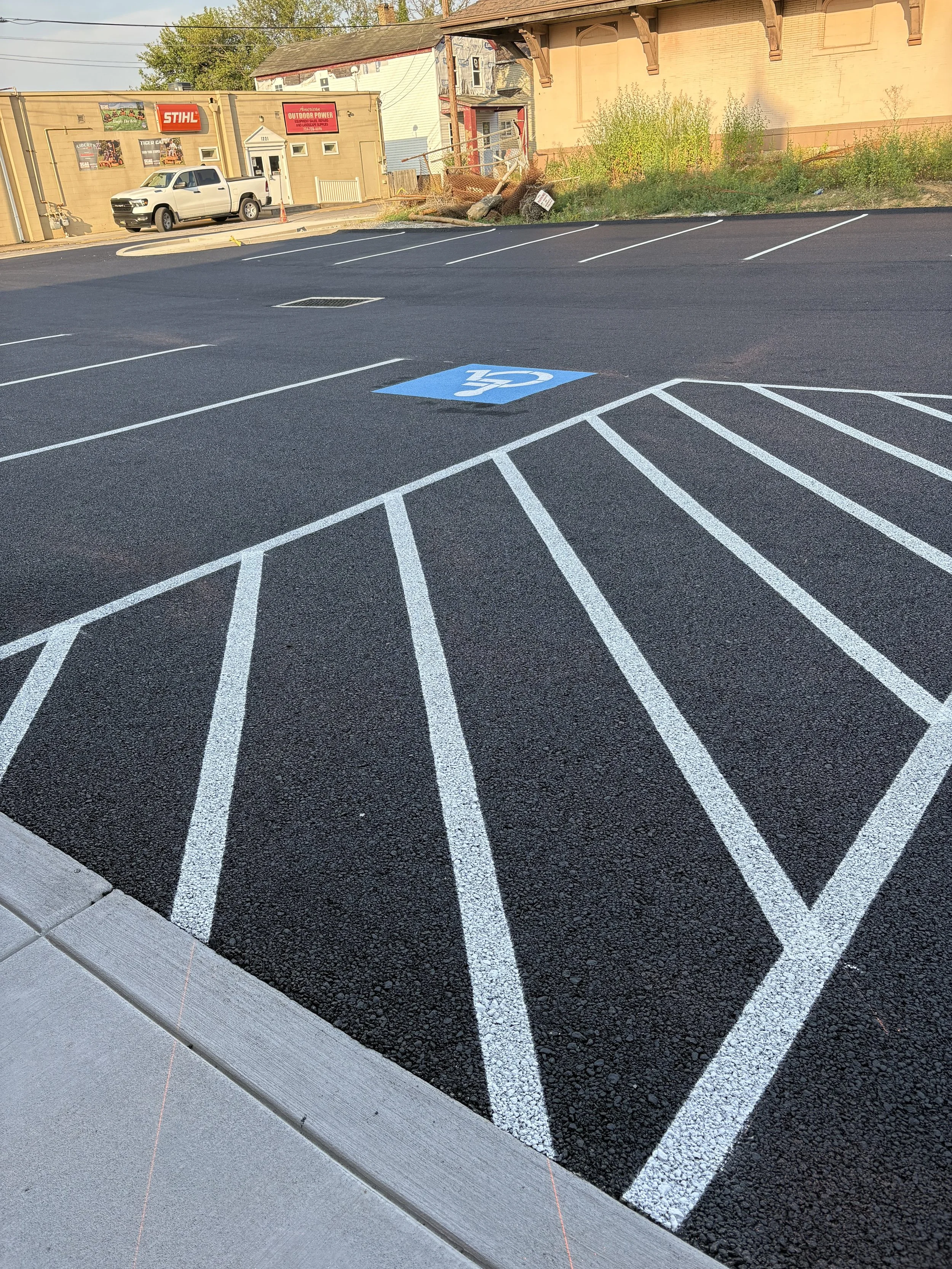 Empty parking lot with spaces marked for handicapped parking, including a blue marked space with a wheelchair symbol.
