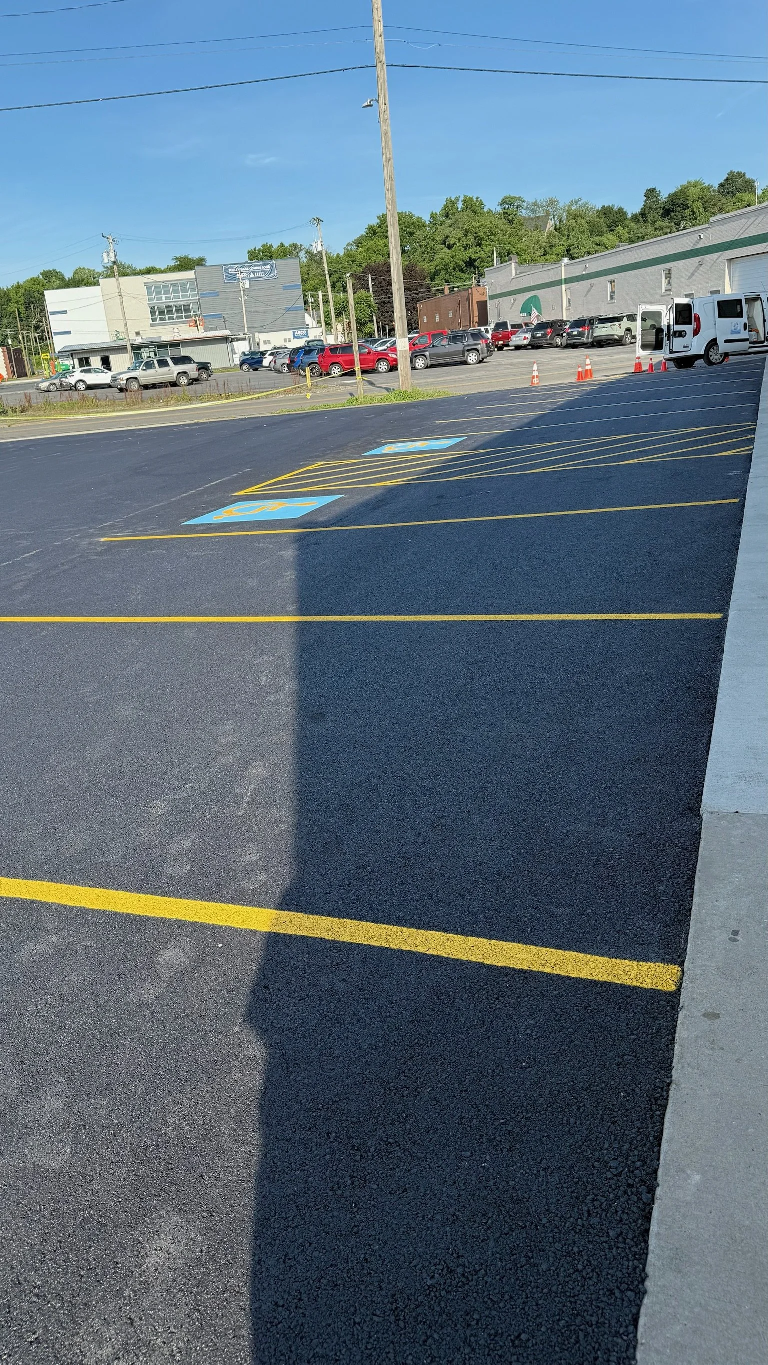 Newly painted parking lot with designated disabled parking spots outlined in blue with wheelchair symbols.