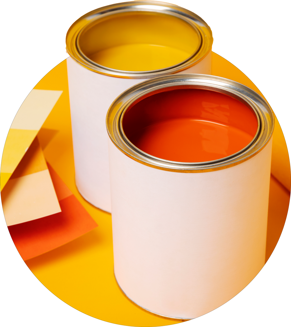 Two open cans of paint, one yellow and one orange, placed on yellow paper with sticky notes nearby.
