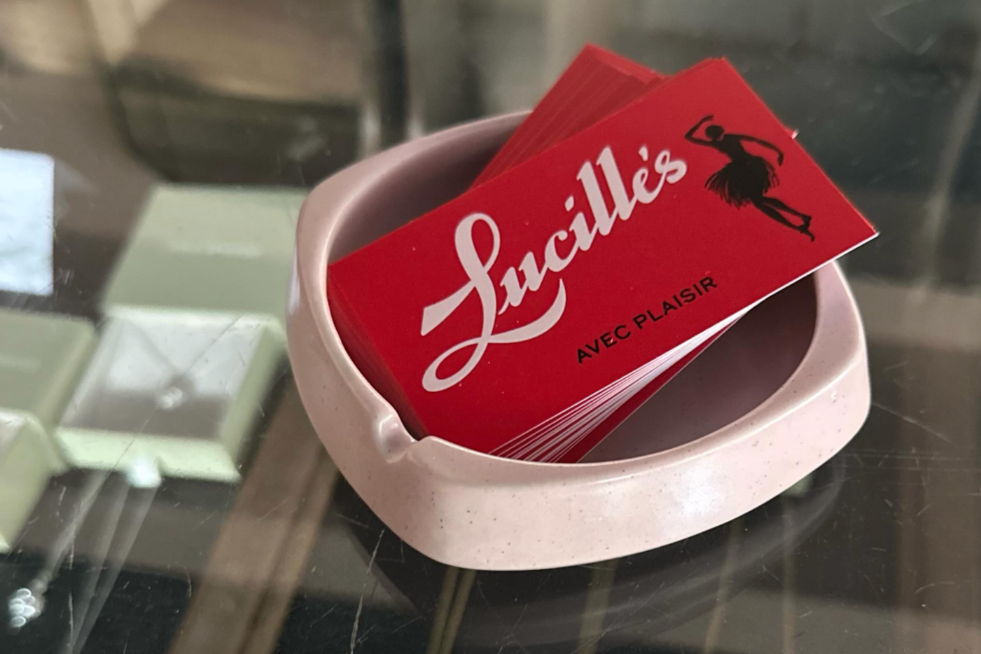 Lucille's business cards in a pink ashtray on a glass display case