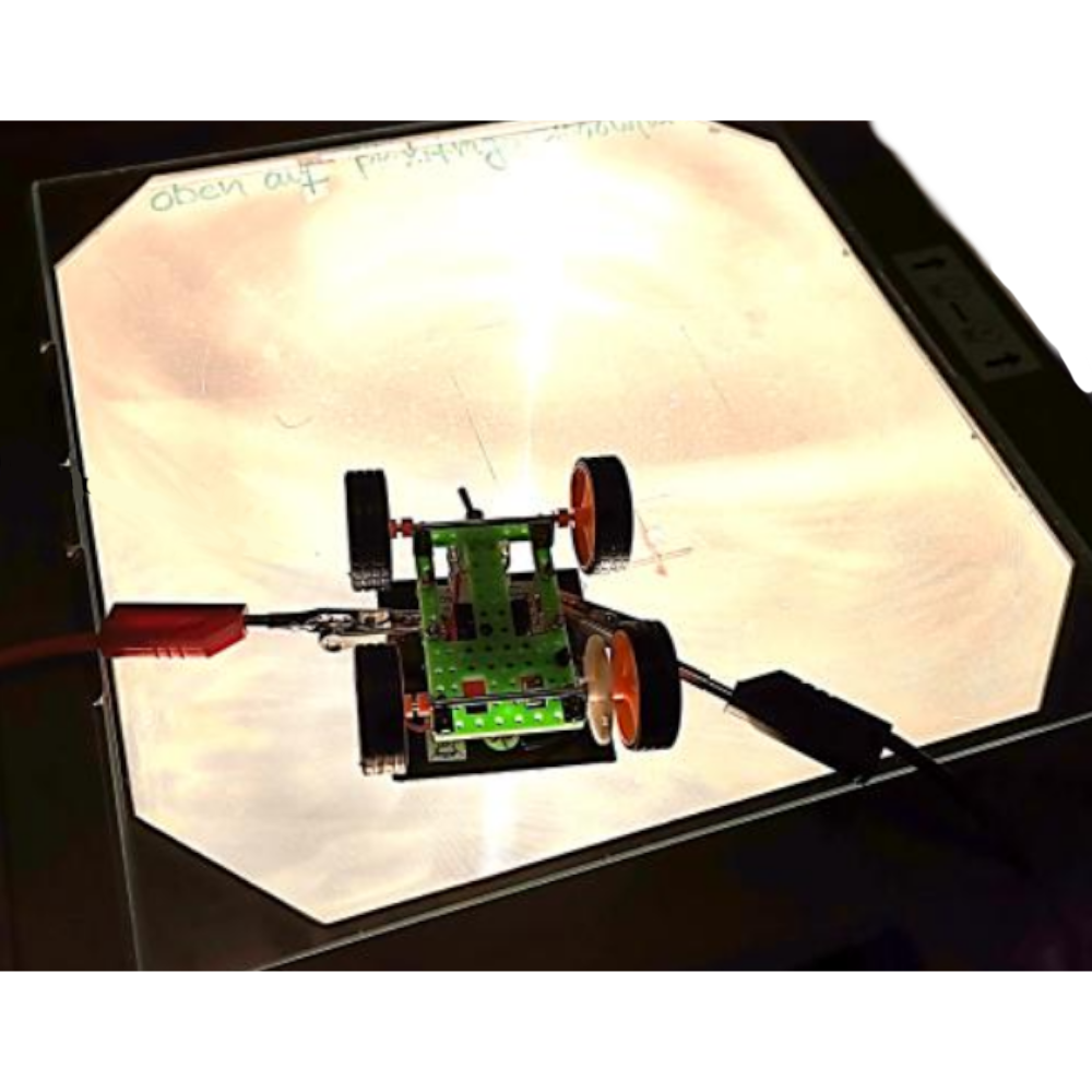 Ein kleines robotisches Fahrzeug auf einem Overheadprojektor bei einer Demonstration.