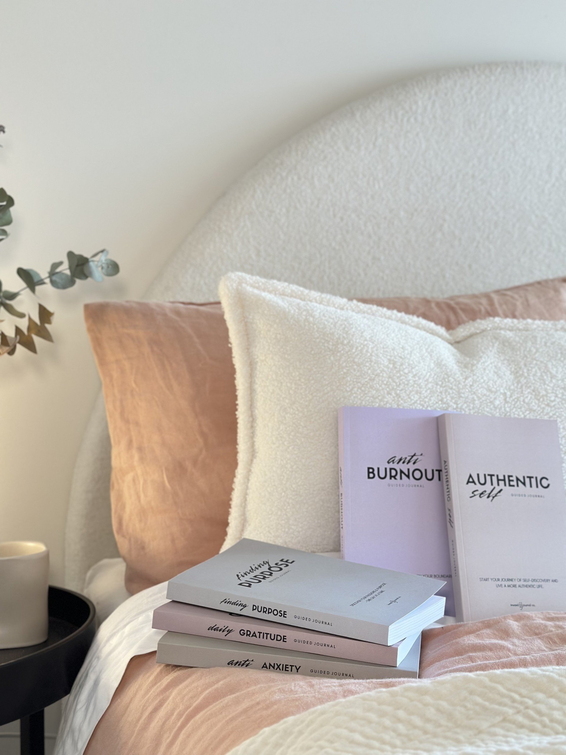 aesthetic journals sitting on a styled bed