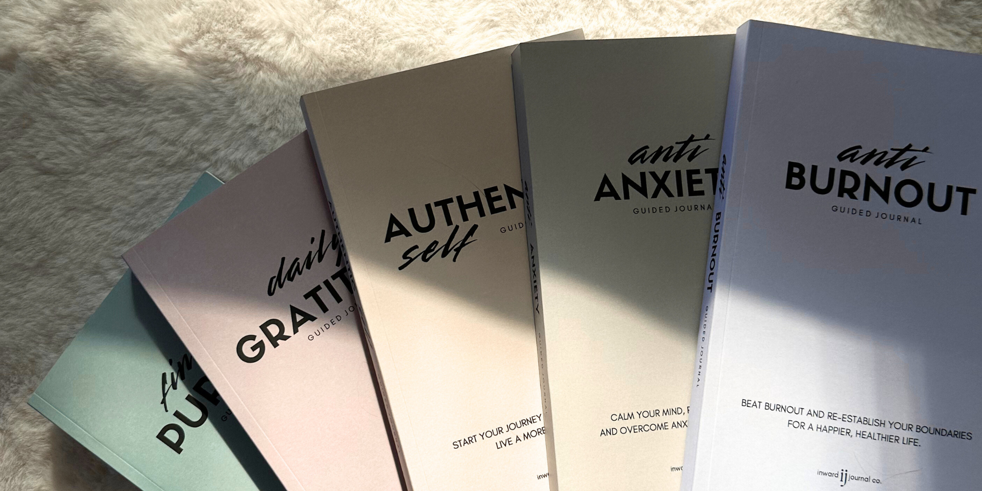 a selection of inward journal co journals on a soft fur background