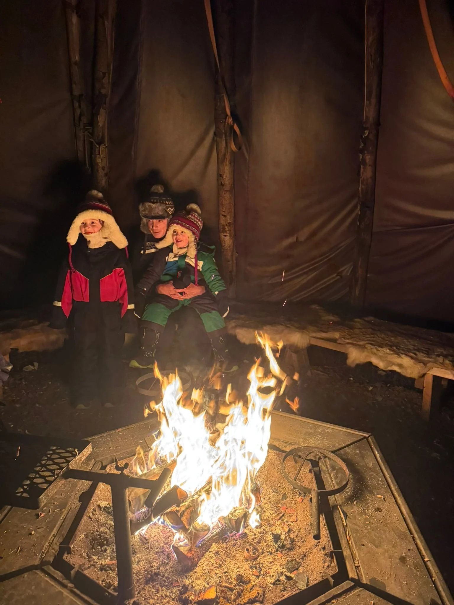 Warming up by the fire, Lapland trip with kids