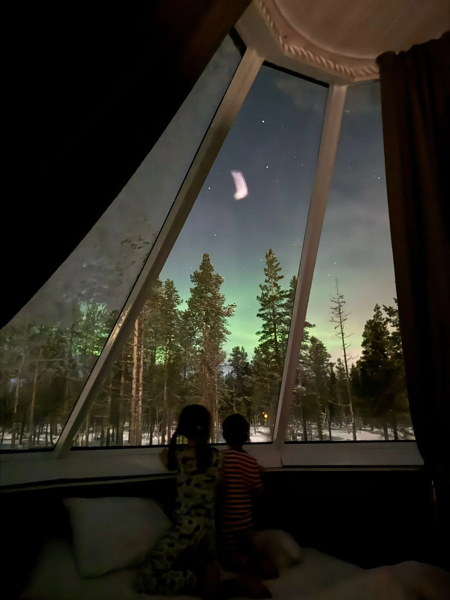 Watching the Aurora from bed, glass roof igloo cabin, Northern Lights Village Saariselka