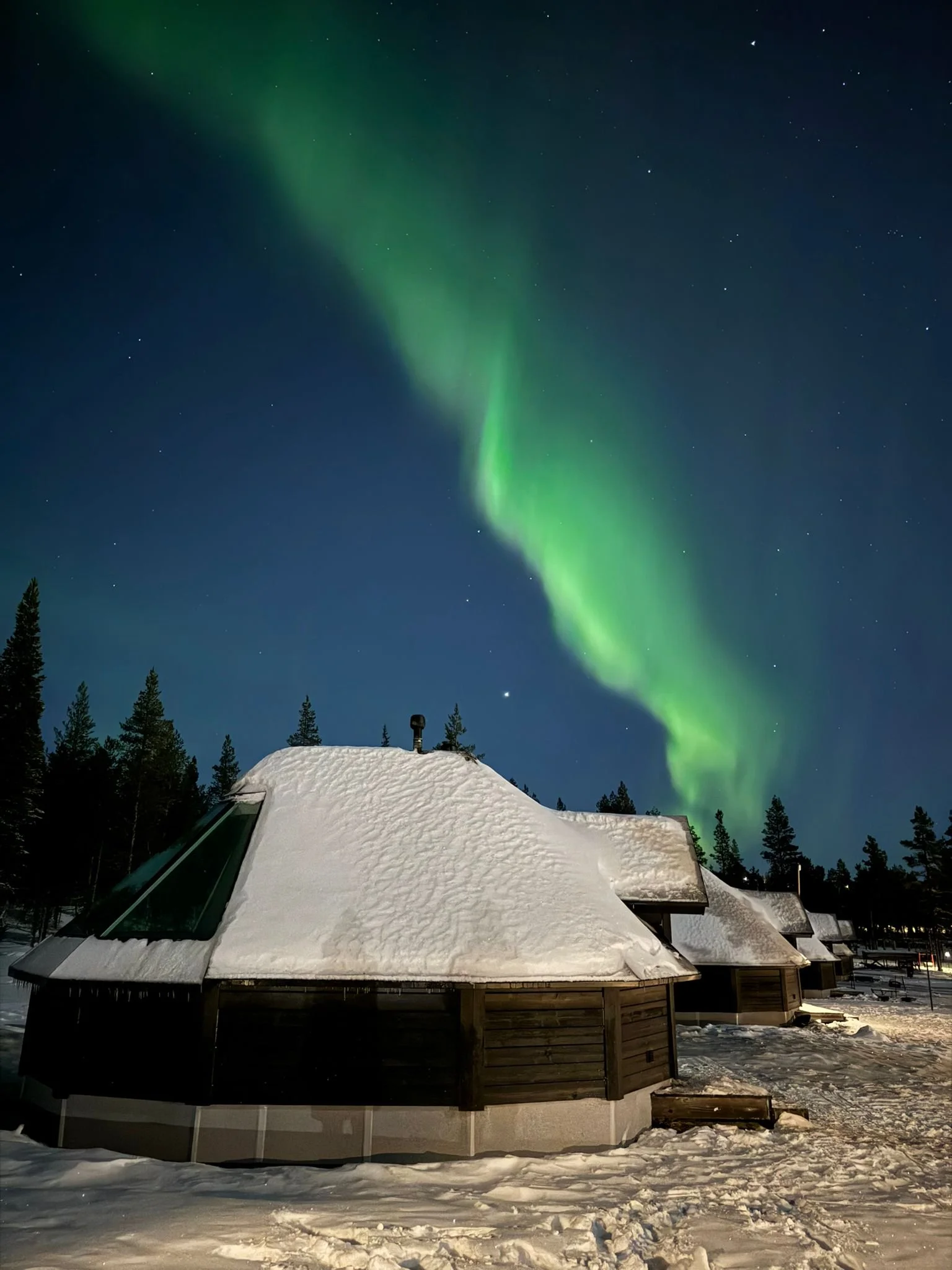 Aurora Borealis over a glass cabin, Northern lights village, saariselka
