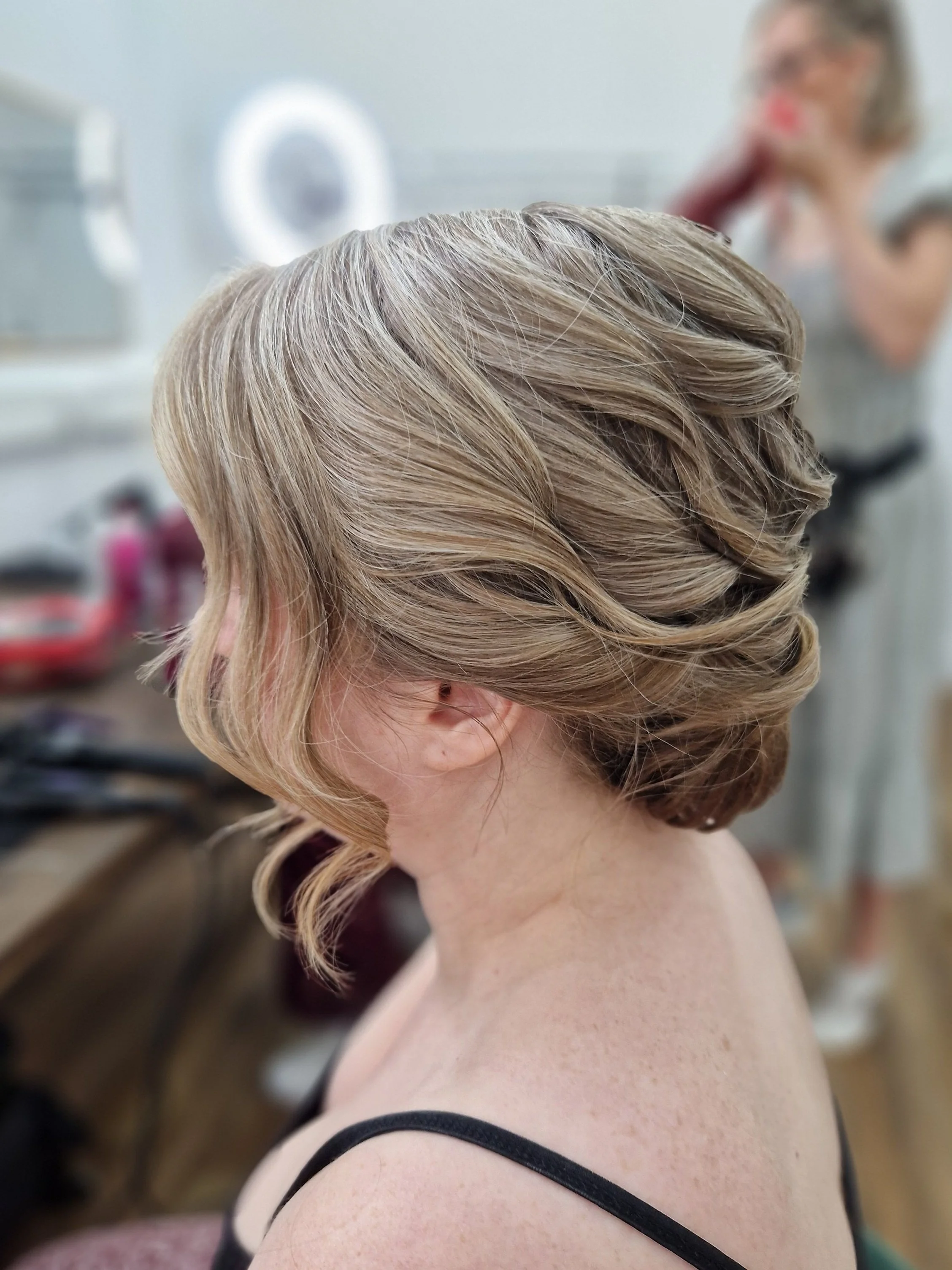 Woman with elegant braided updo hairstyle at salon