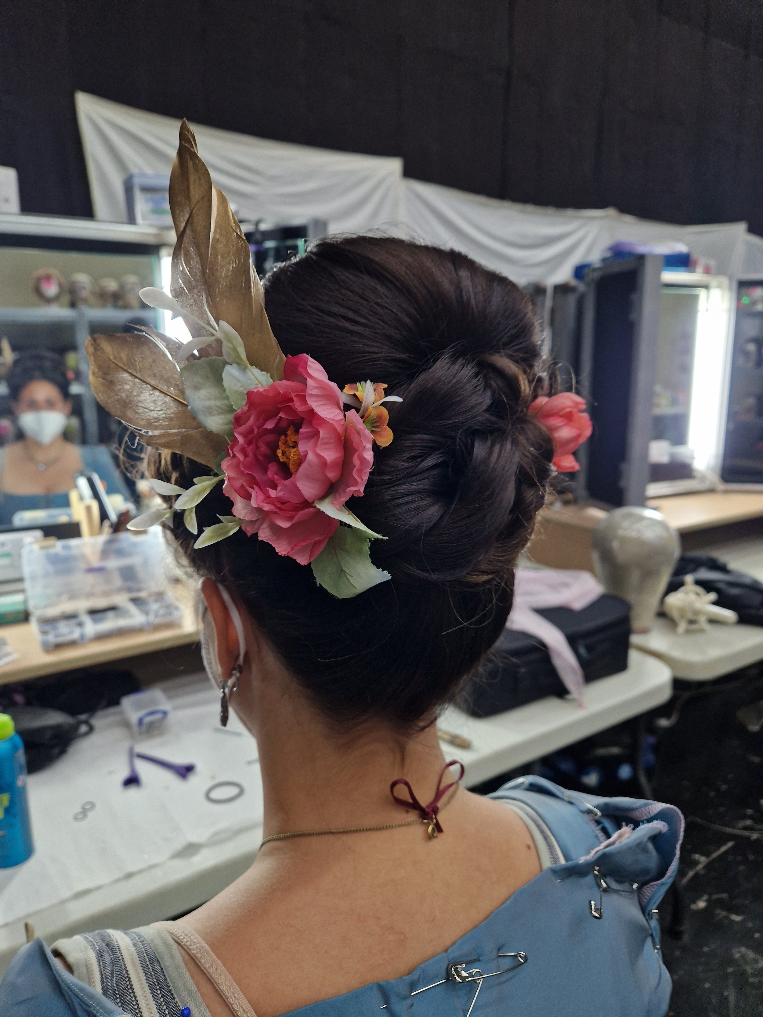 Woman with floral hairpiece and bun in a dressing room