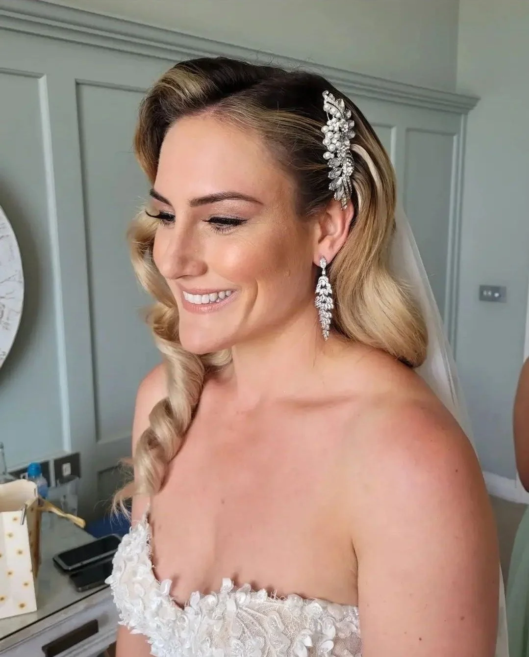 Bride smiling wearing white lace wedding dress and diamond accessories