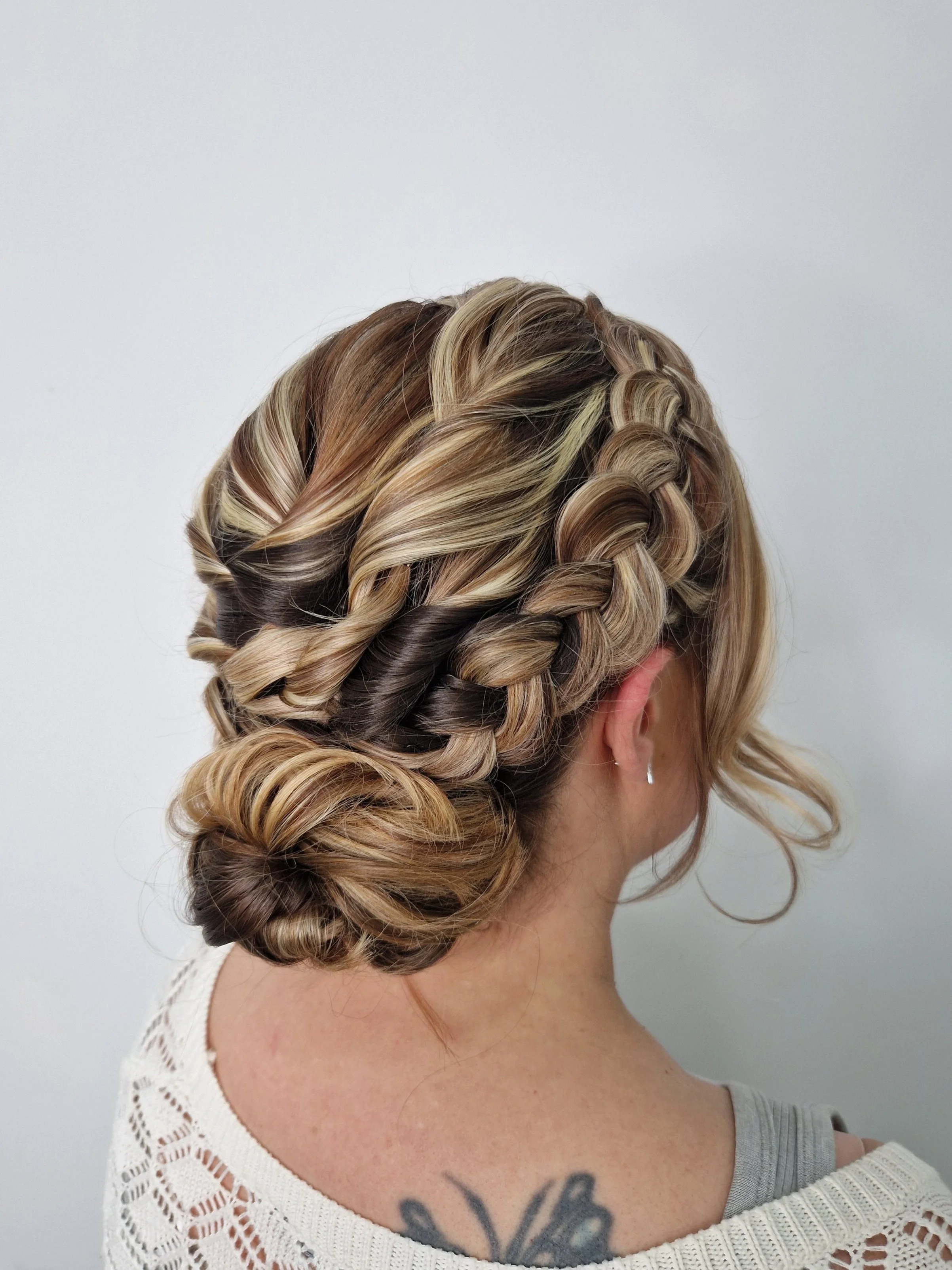 Woman with braided blonde hair styled in an updo