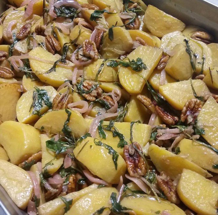 Roasted Golden Beets with pecans, Pickled Red onions, and wilted arugula in a tray.