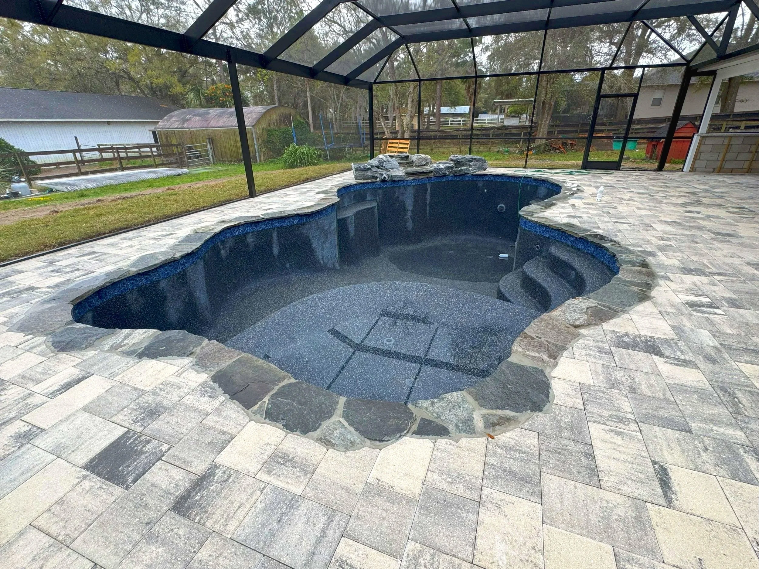 Midnight Blue Pebble with Flagstone Coping and  Custom Natural Rock Feature