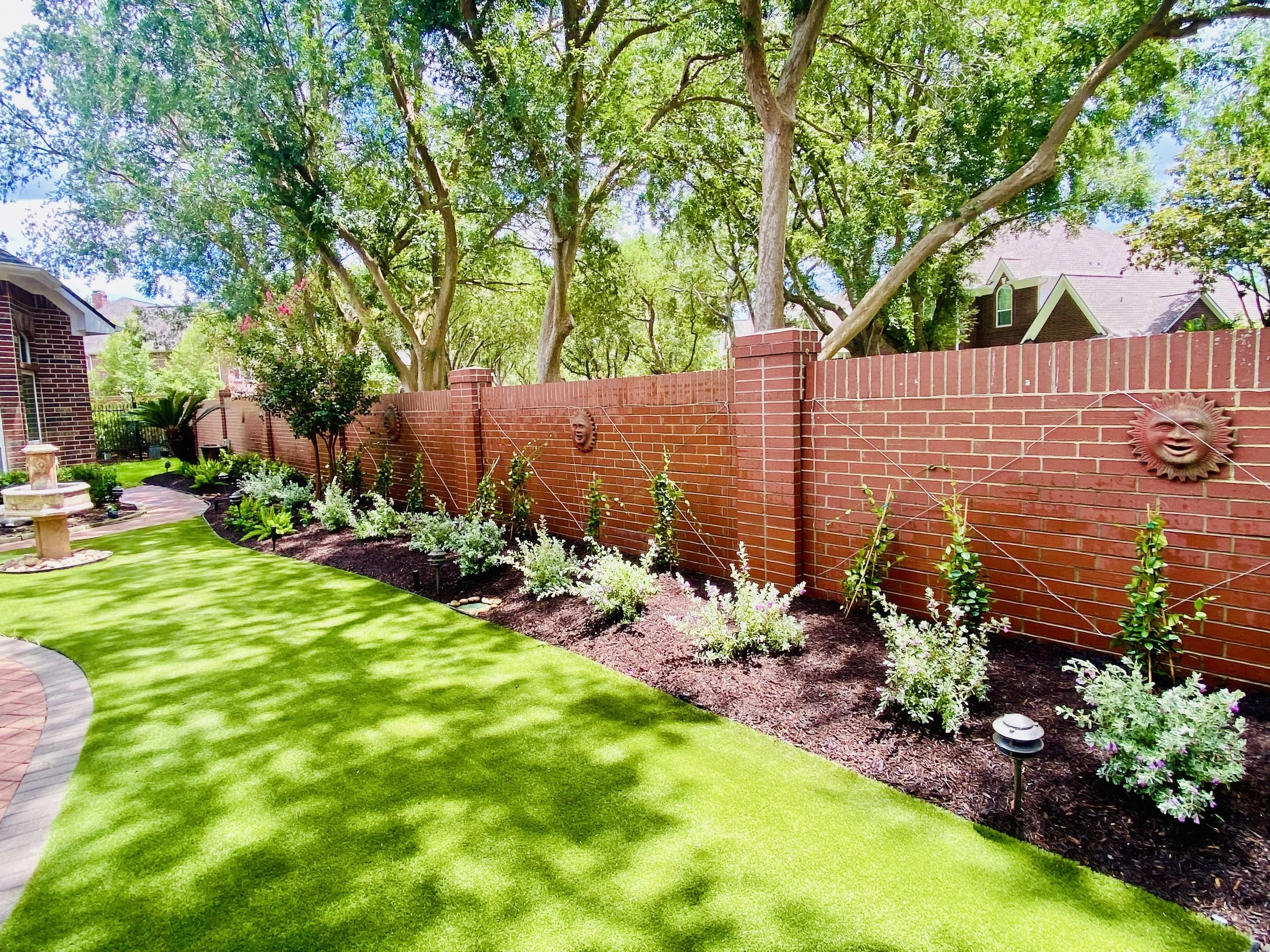 Texas sage and azaleas installed beside a red brick home in Sugar Land TX