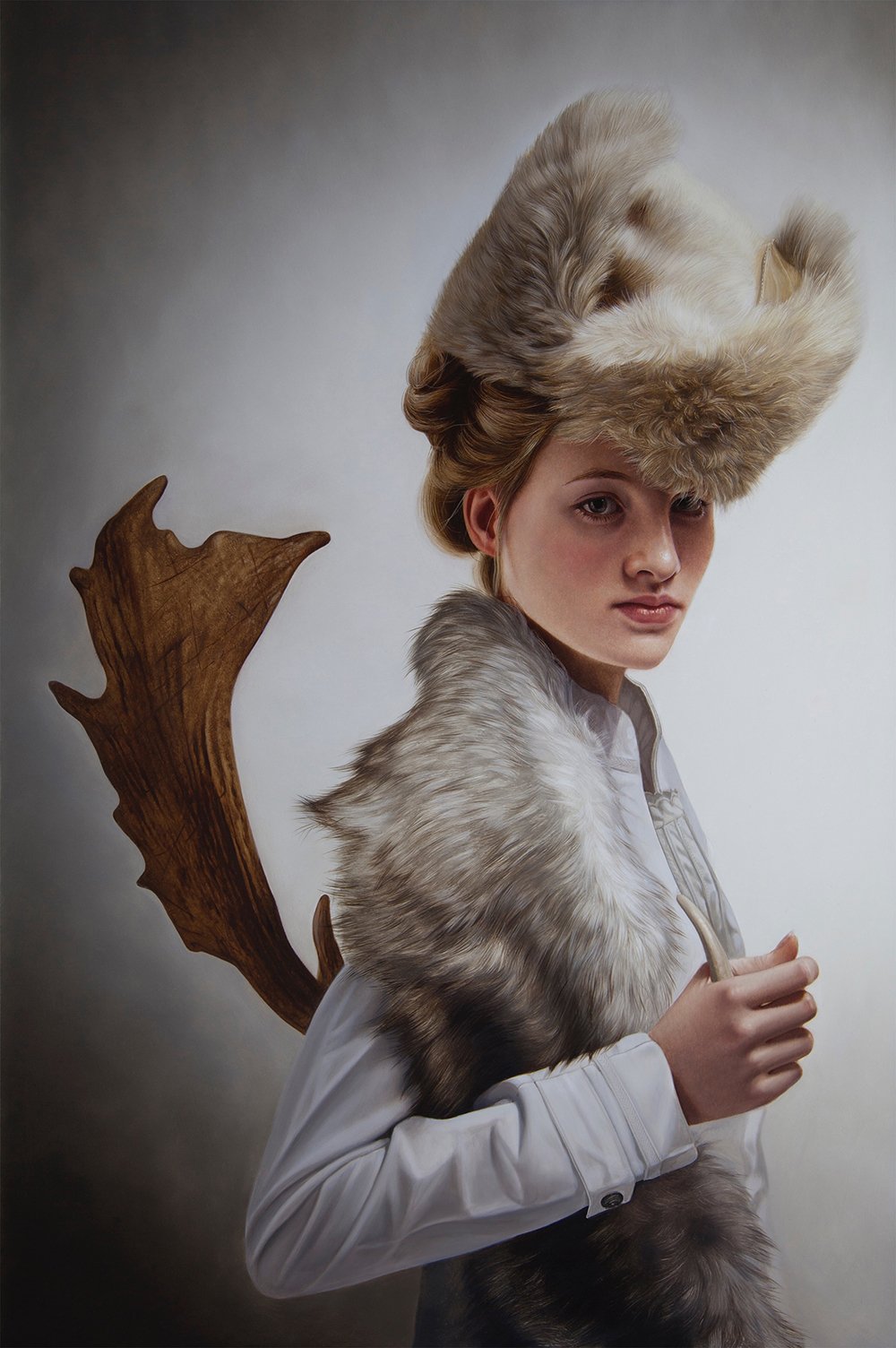 A woman with elaborate fur hat and fur shoulder wrap, holding a small object, against a neutral background.