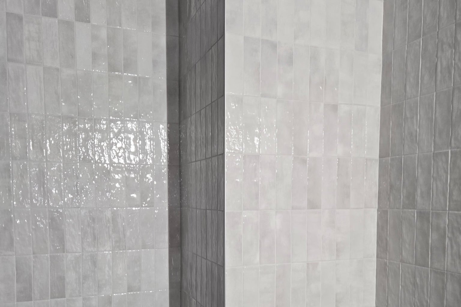Glossy white tiled wall with light gray grout