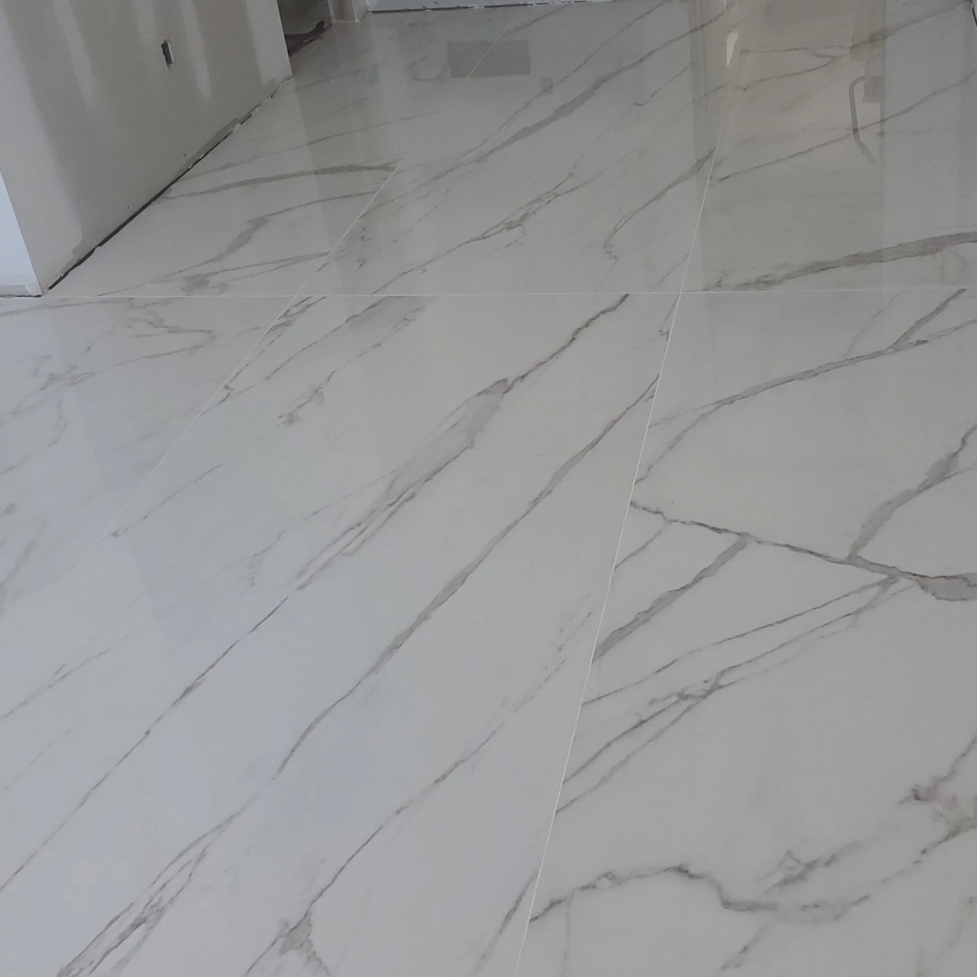 Polished white marble floor with gray veining, featuring large square tiles.