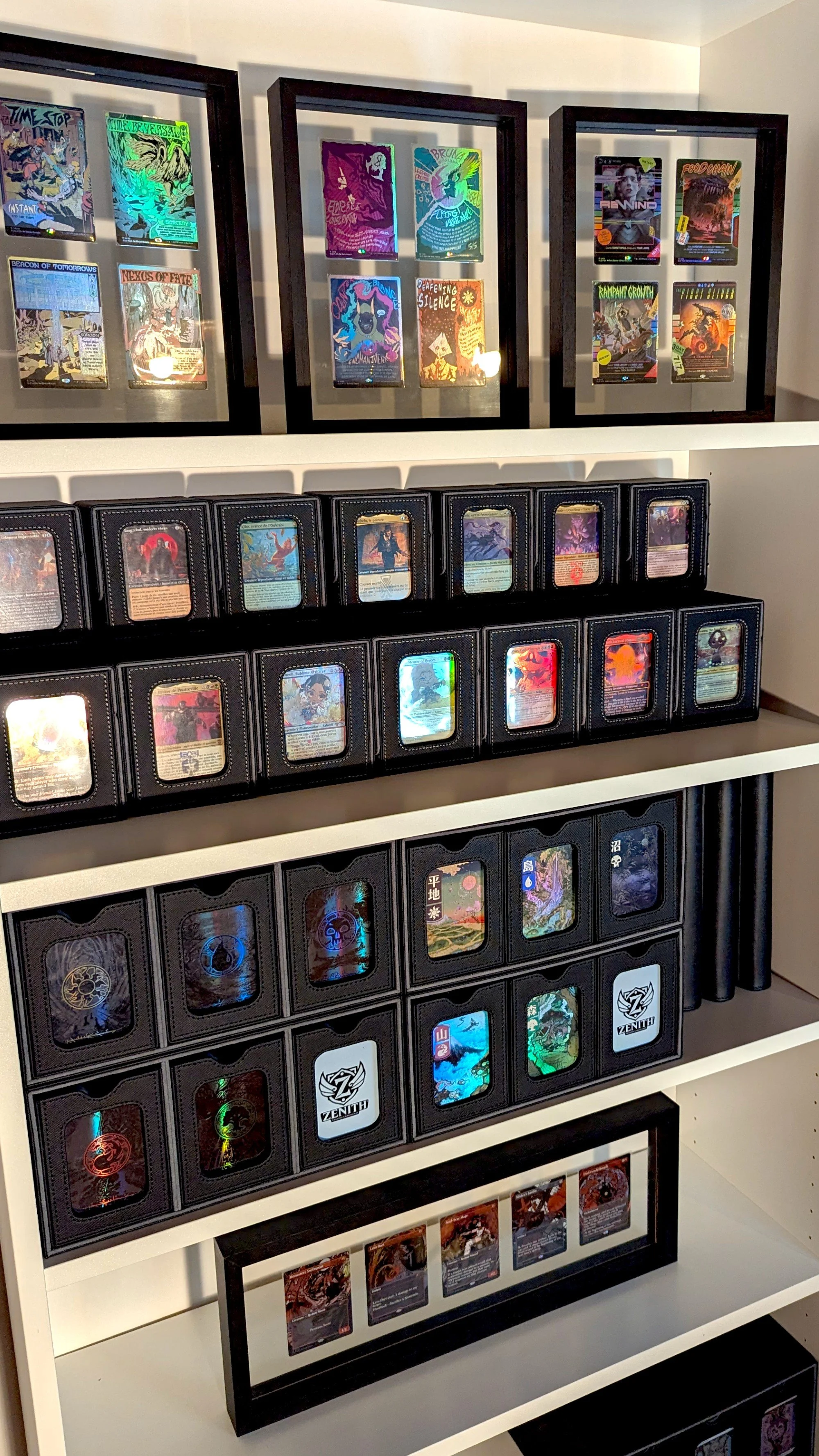 Une étagère contenant des paquets de cartes de jeu ou des cartes à collectionner, avec plusieurs cadres exposant des cartes dans des cadres noirs en haut.