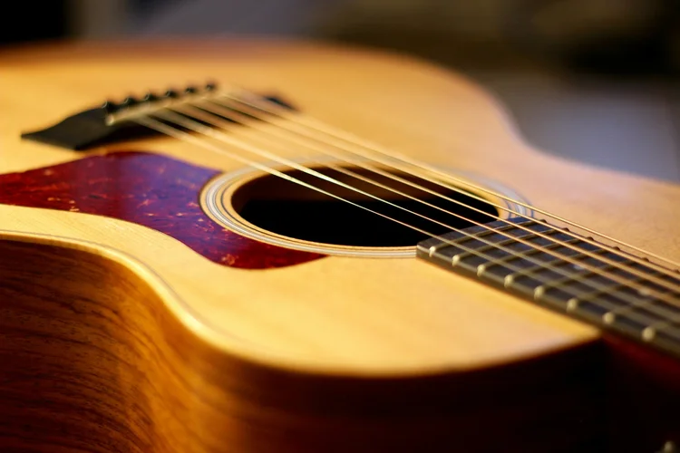 Acoustic guitar resting in low light