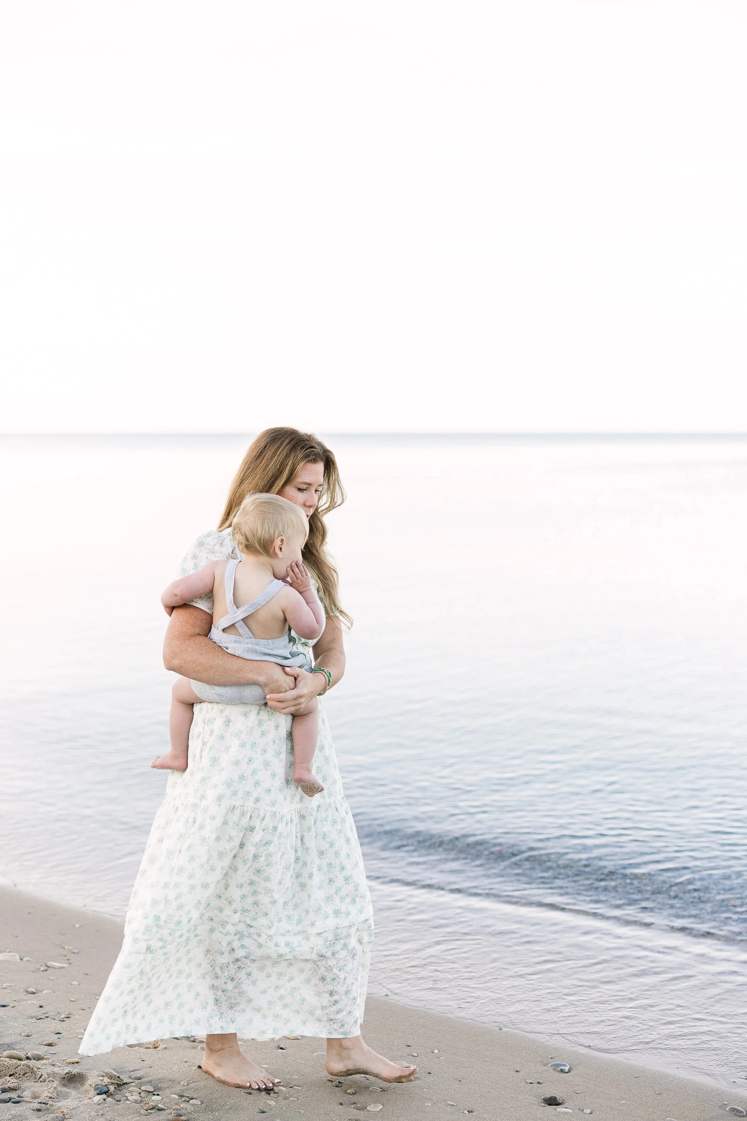 A photo of a mother and son walking along the beach in northern michigan