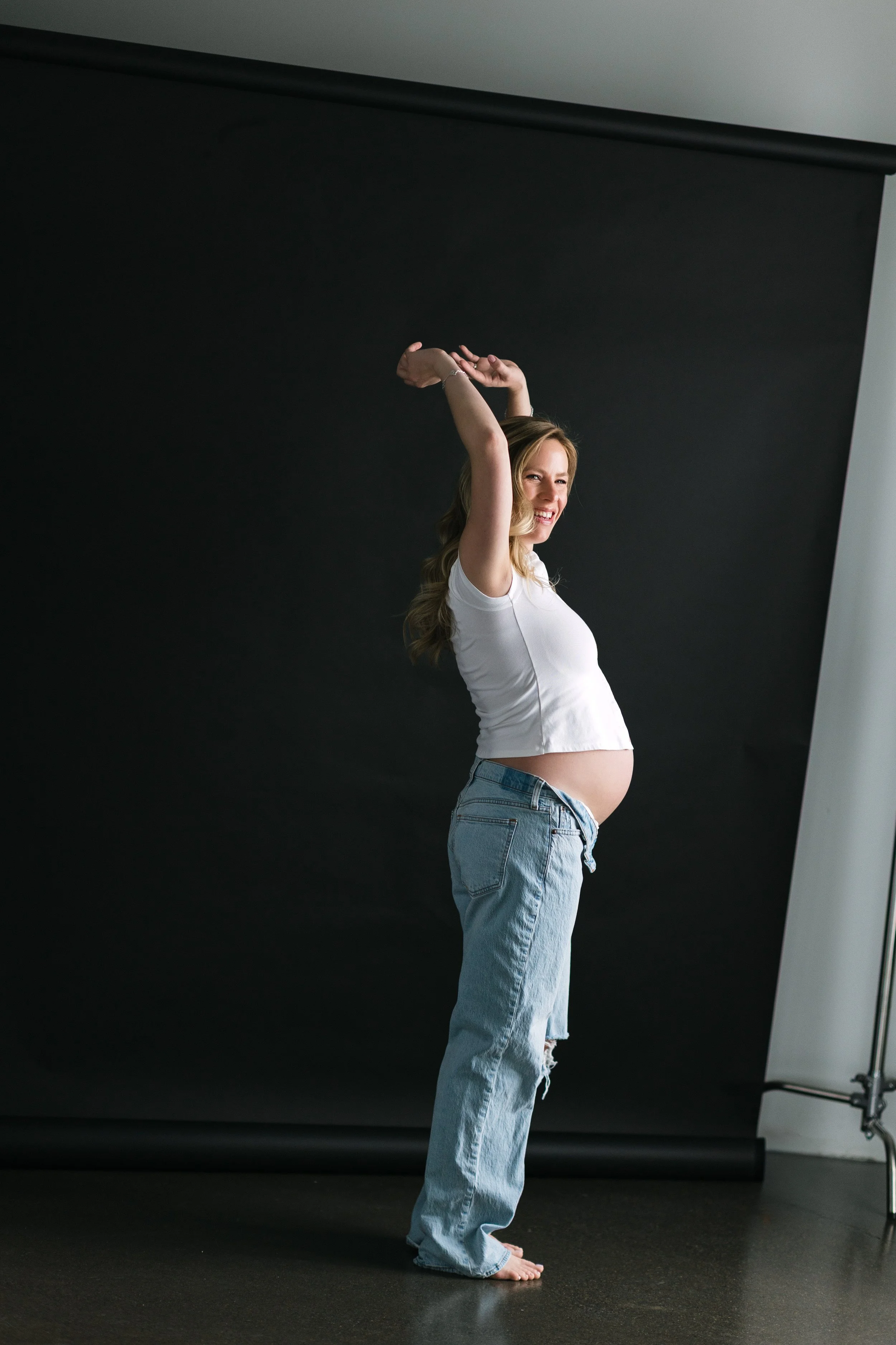 A portrait of a pregnant woman smiling in a traverse city photography studio