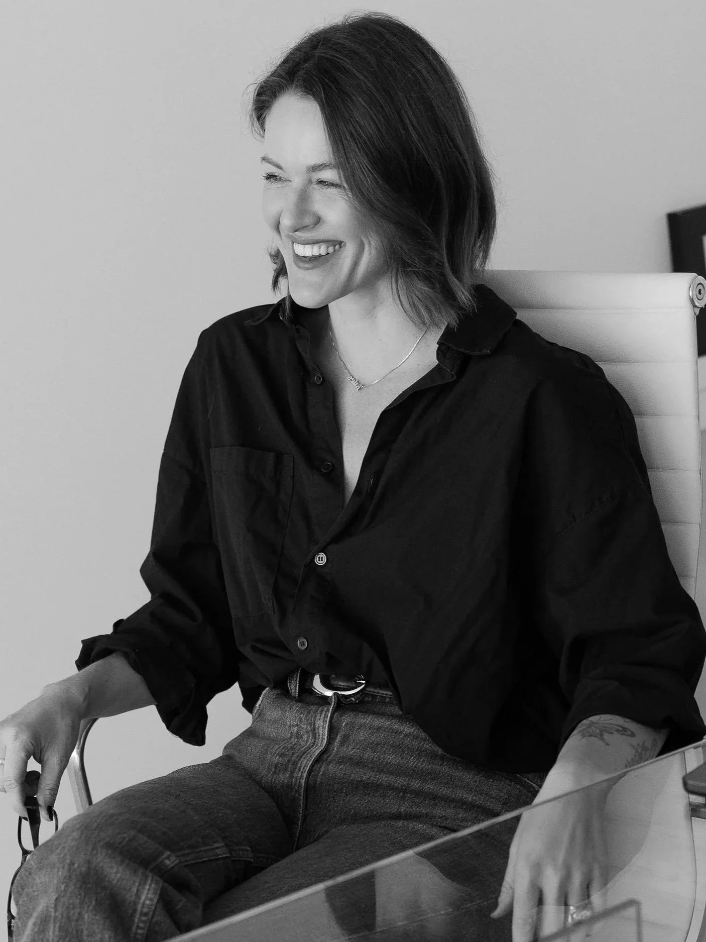 A photo of a female photographer at her desk smiling in her photography studio