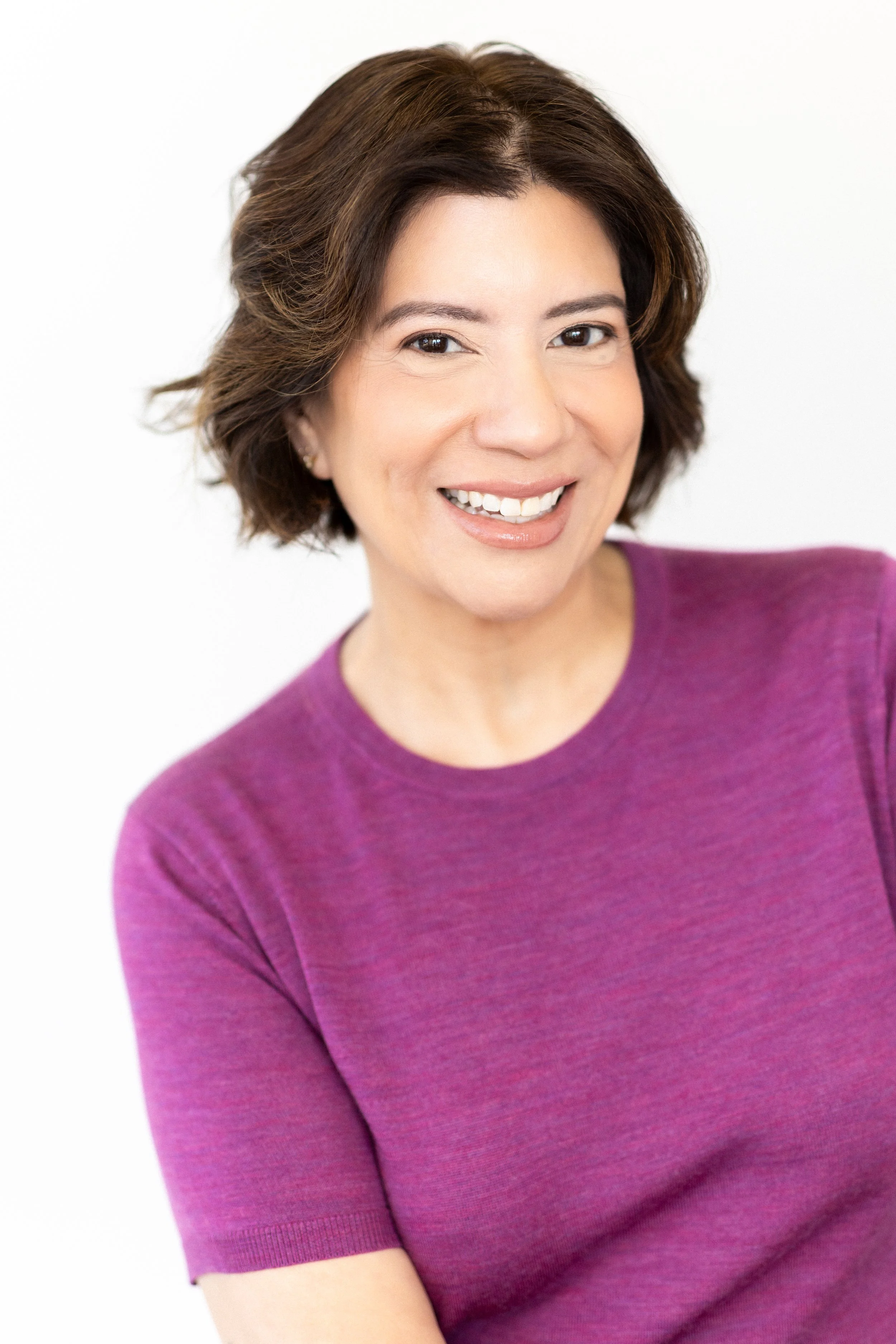 Women smiling in purple sweater for her lifestyle modern headshot session at traverse city photography studio house of 301