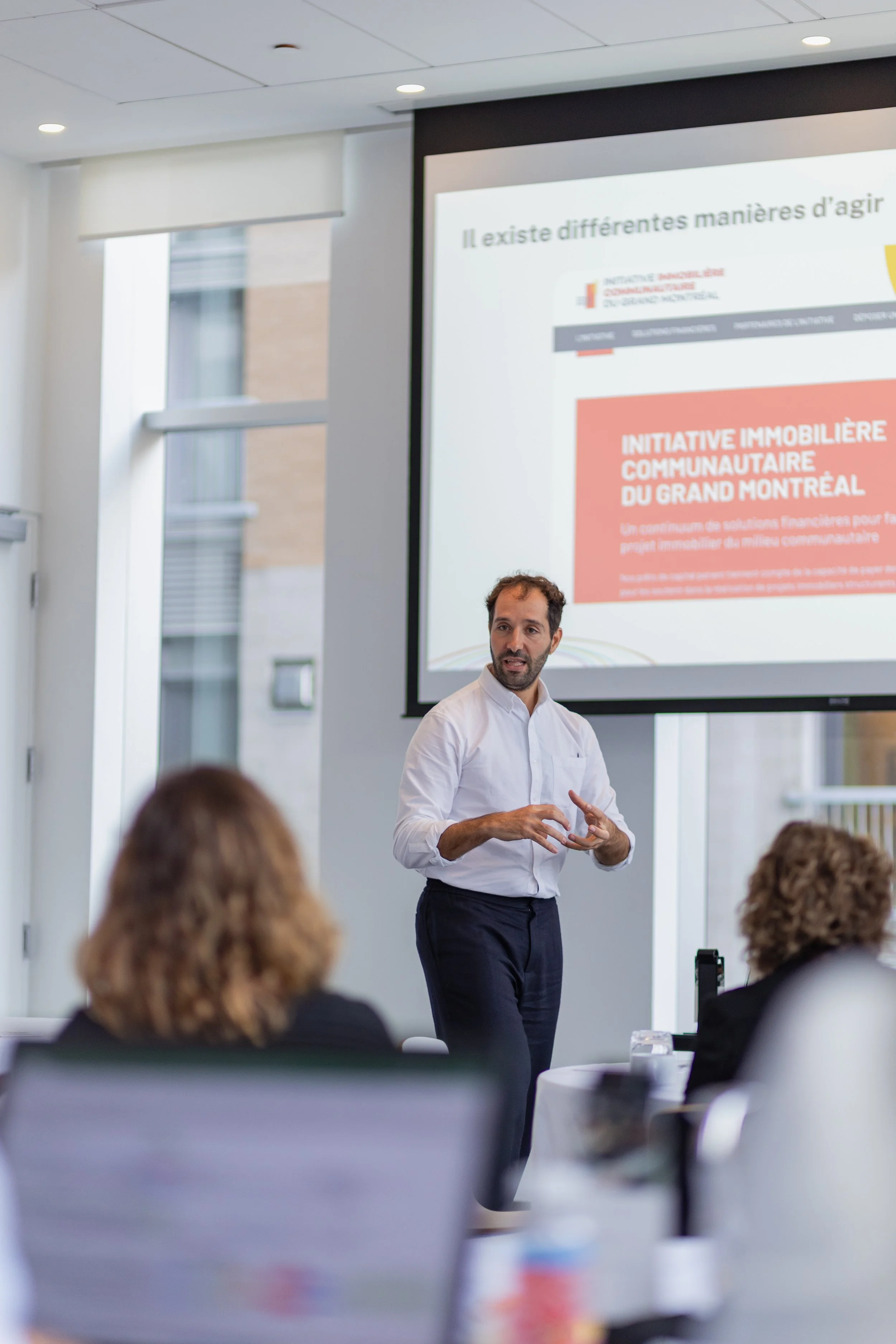 Membre d’Estuaire présente devant un groupe lors d’un atelier; diapositive projetée à l’écran.