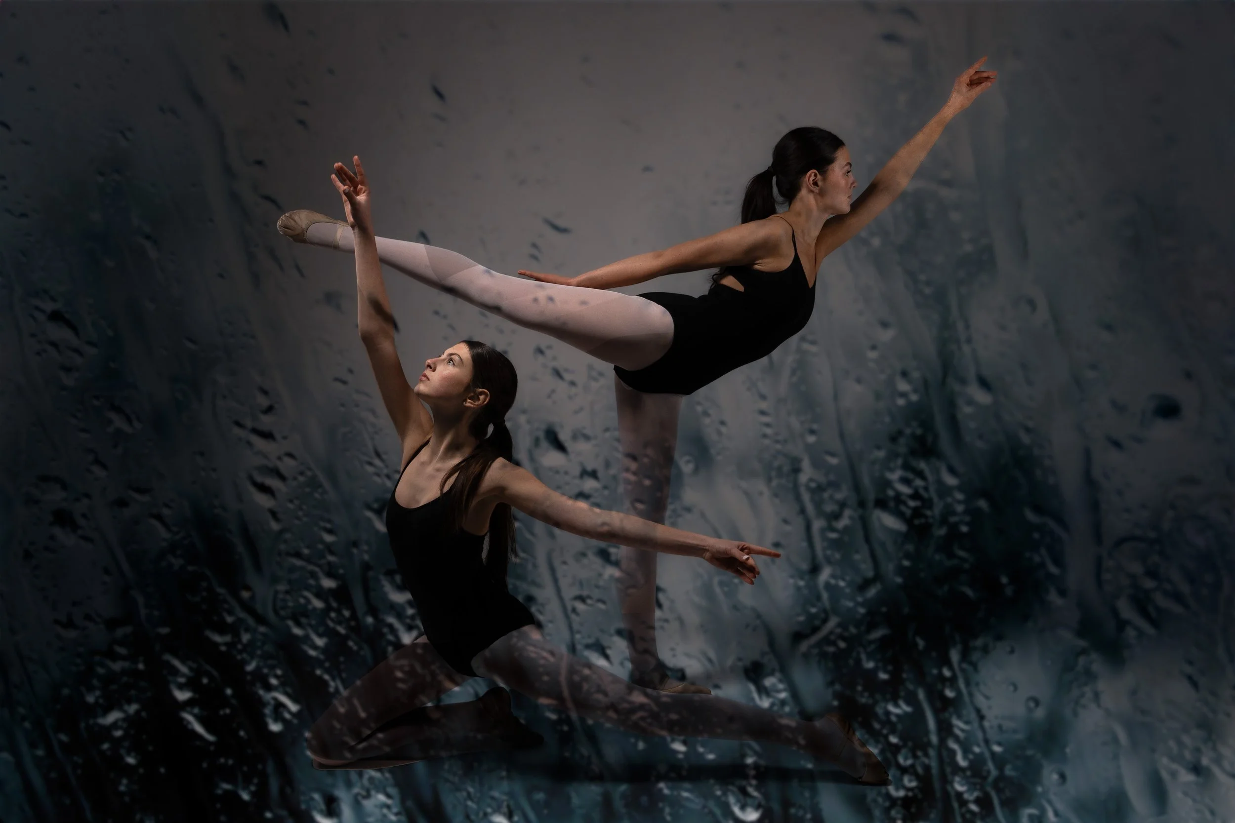 Two ballet dancers performing a pose with a dark water droplet background.
