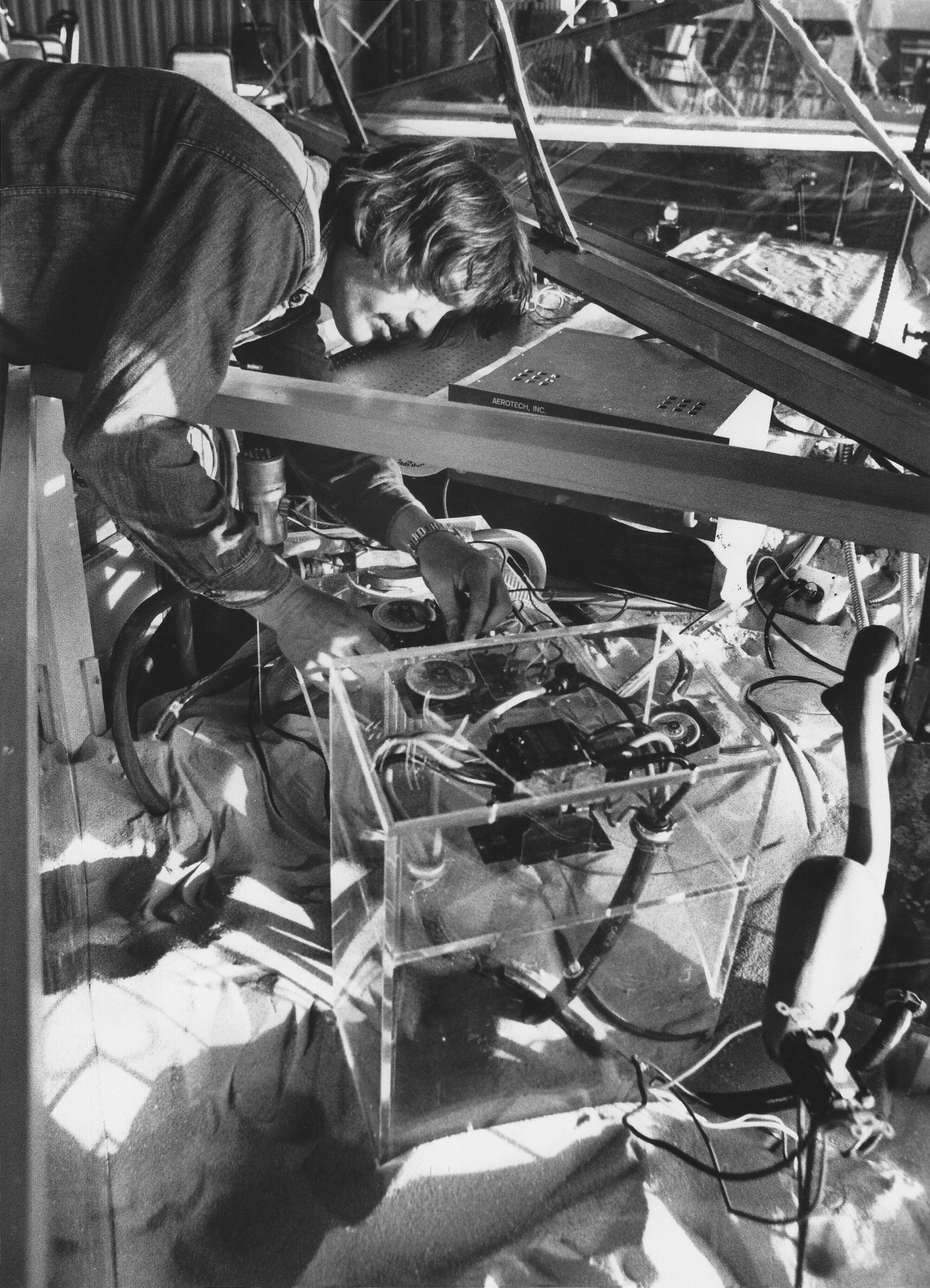 Photo by Weaver Tripp, St. Petersburg Times, 1976. Artist Rockne Krebs is leaning over his Plexiglas art installation piece, Starboard, Home on the Range, Part VI, he built to house the laser.
Excerpts- “Krebs is setting prism timers and working on t