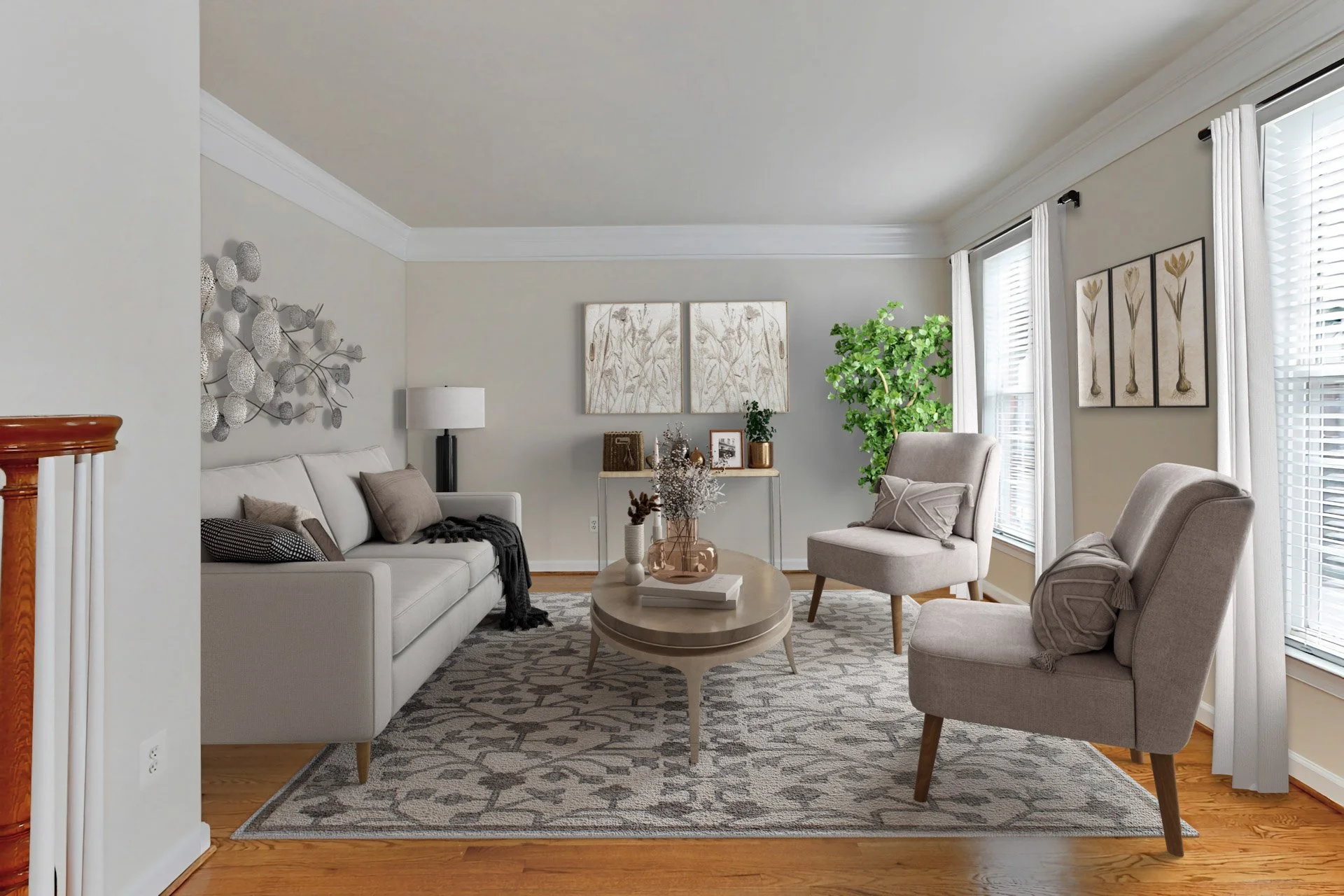 Bright living room with light gray walls, white couch, two matching beige armchairs, a patterned area rug, coffee table with vases and decor, large windows with white curtains, houseplant, wall art, and a table with decorations on the back wall.