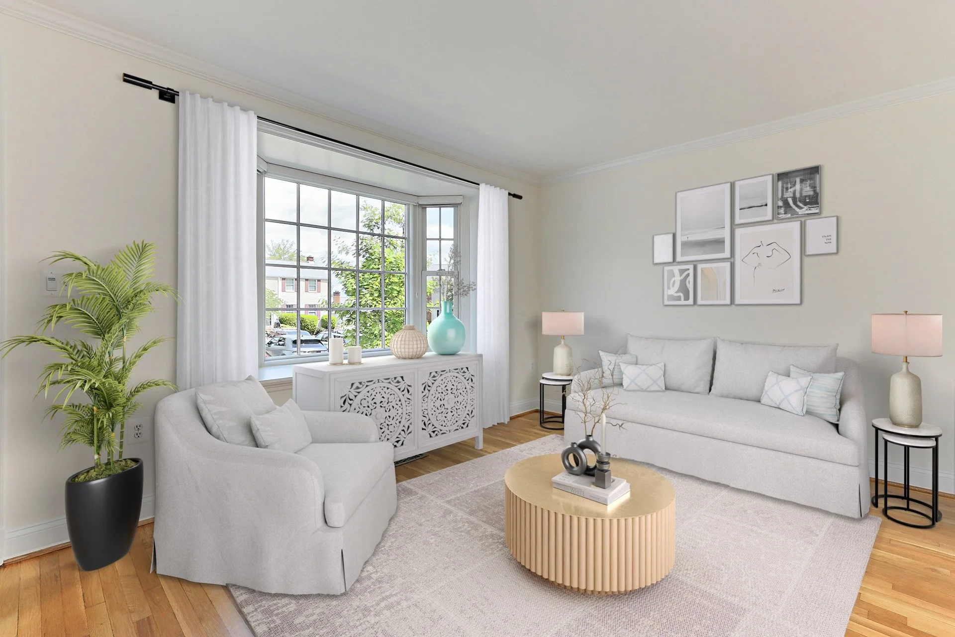 Bright living room with a large window, white curtains, white sofa with pillows, a white armchair, a round beige coffee table, two side tables with lamps, a wall gallery, potted plant, and decorative vases.