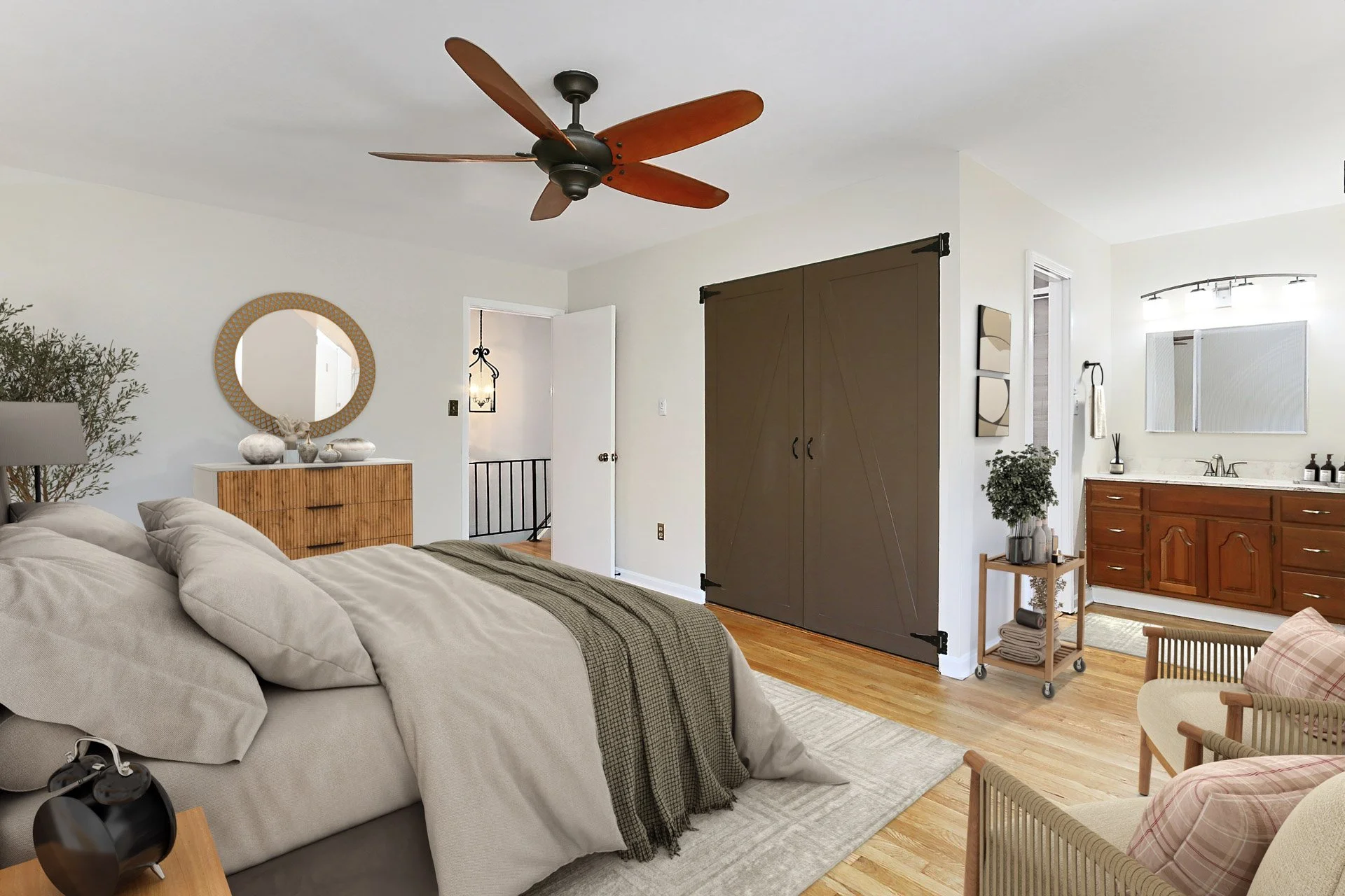Living room with beige sofa, wooden side table, ceiling fan, and view into a bathroom with wooden vanity and mirror.