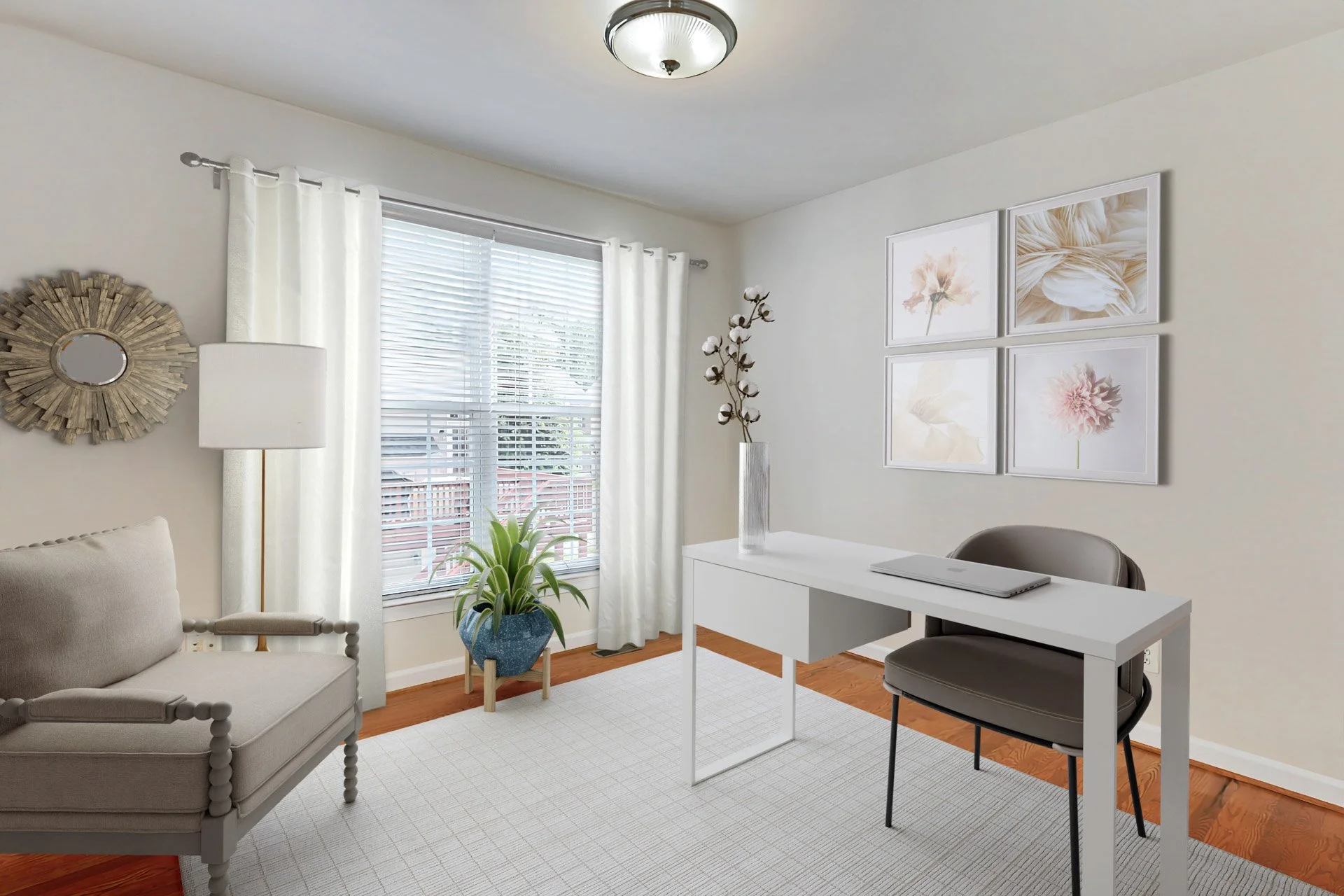 A bright, minimalistic home office with a white desk, gray chair, beige armchair, white curtains, potted plant, wall art, and a ceiling light.