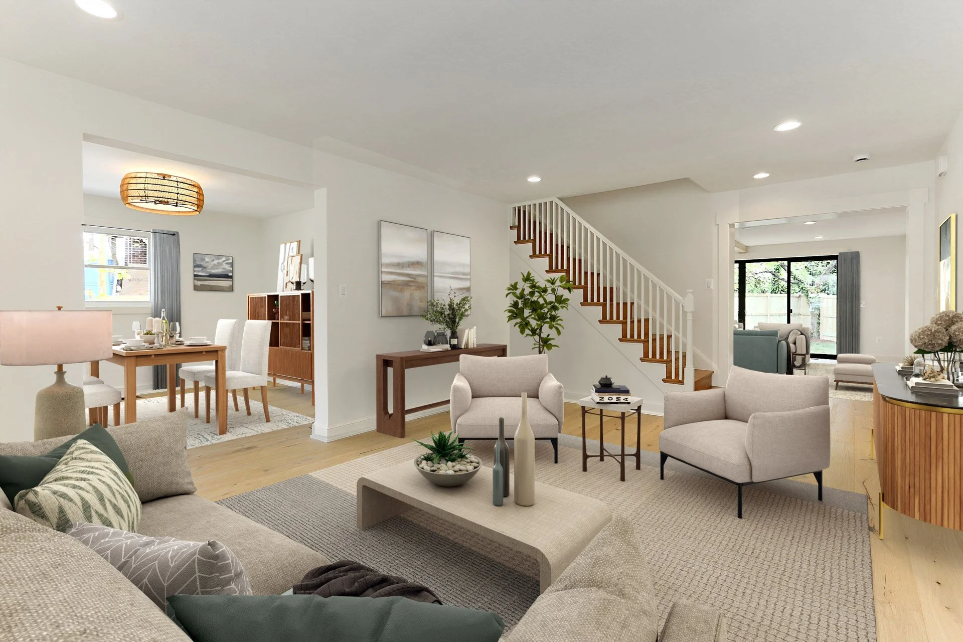 Bright open living room with a beige sofa, two armchairs, a coffee table with decorative vases, and a corner with a sideboard. Adjacent dining area has a wooden table with white chairs, and a staircase with wooden steps and white railing leads upstai