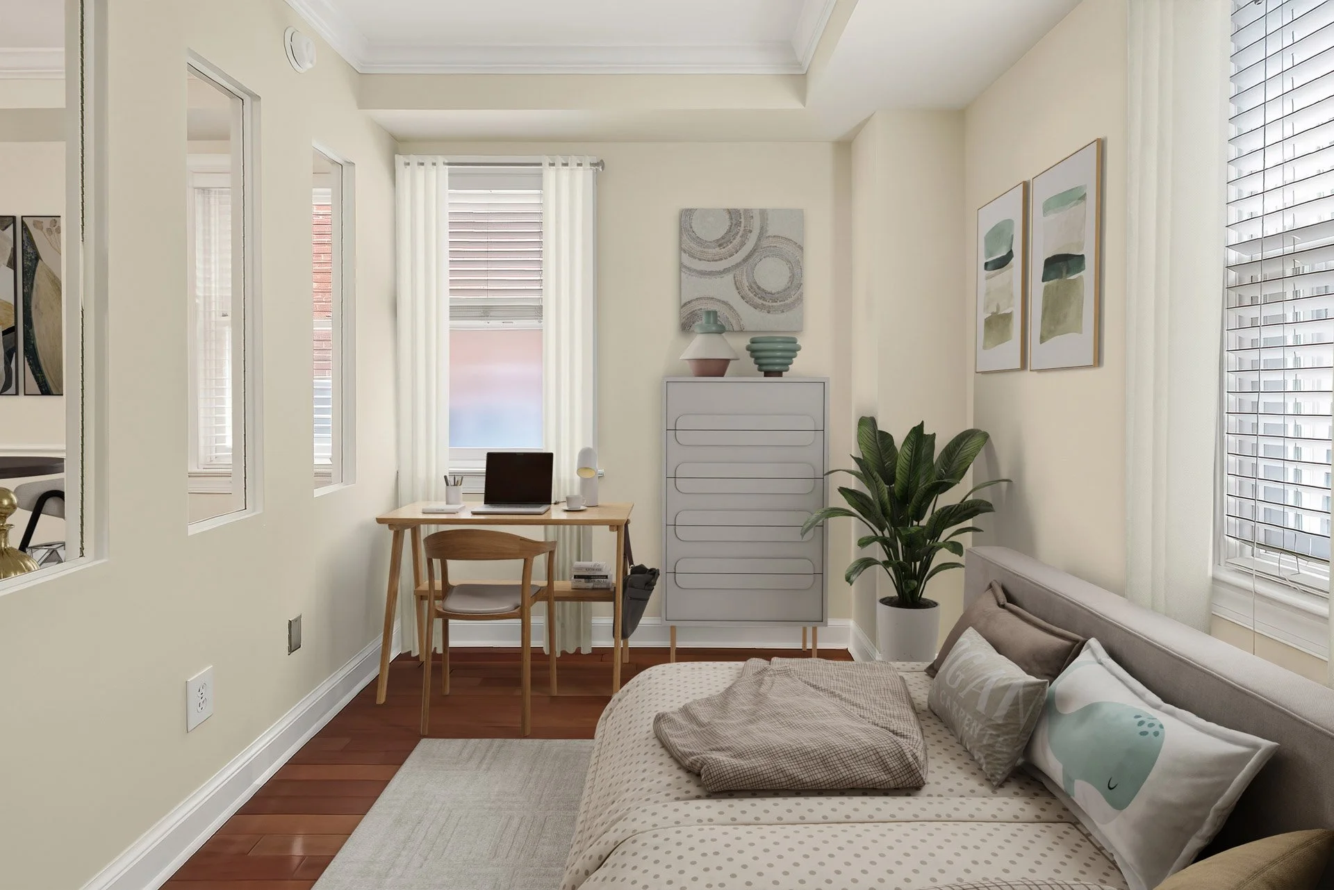 A cozy bedroom with a desk near two windows, a bed with pillows, a potted plant, and artwork on the walls.