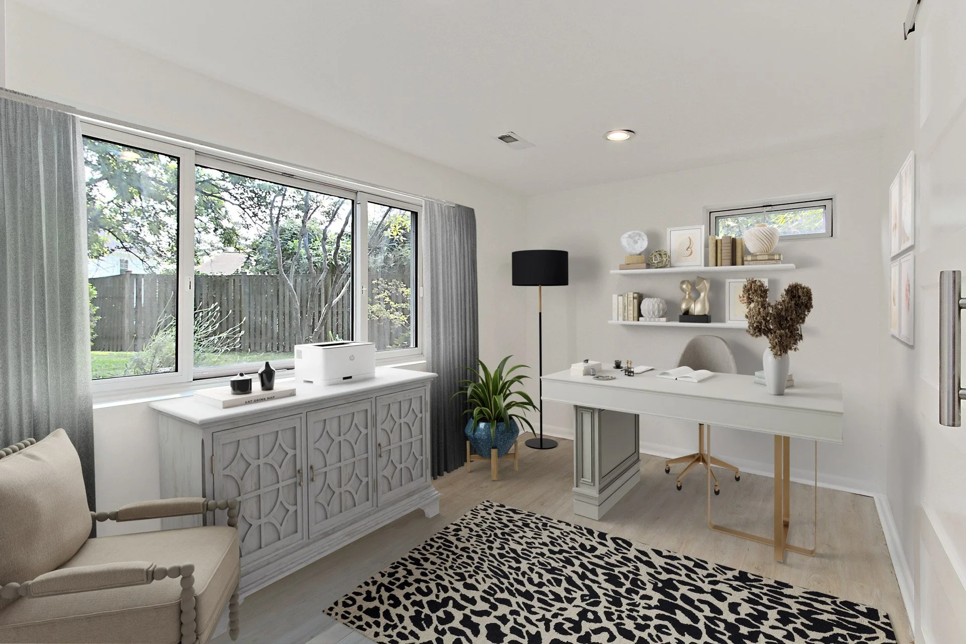 A modern home office with a white desk, beige chair, black floor lamp, white shelves with decorative items, a window with gray curtains, a beige armchair, a potted plant, and a black and white animal print rug.
