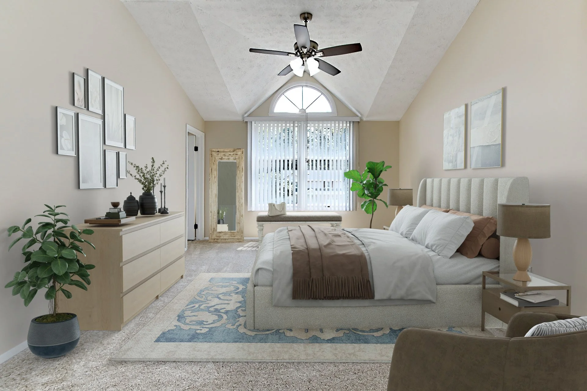 Bright bedroom with beige walls, vaulted ceiling, ceiling fan, large window with blinds, beige bed with white and brown bedding, nightstands with lamps, potted plants, wall art, dresser with decorative objects, full-length mirror, and a sitting chair