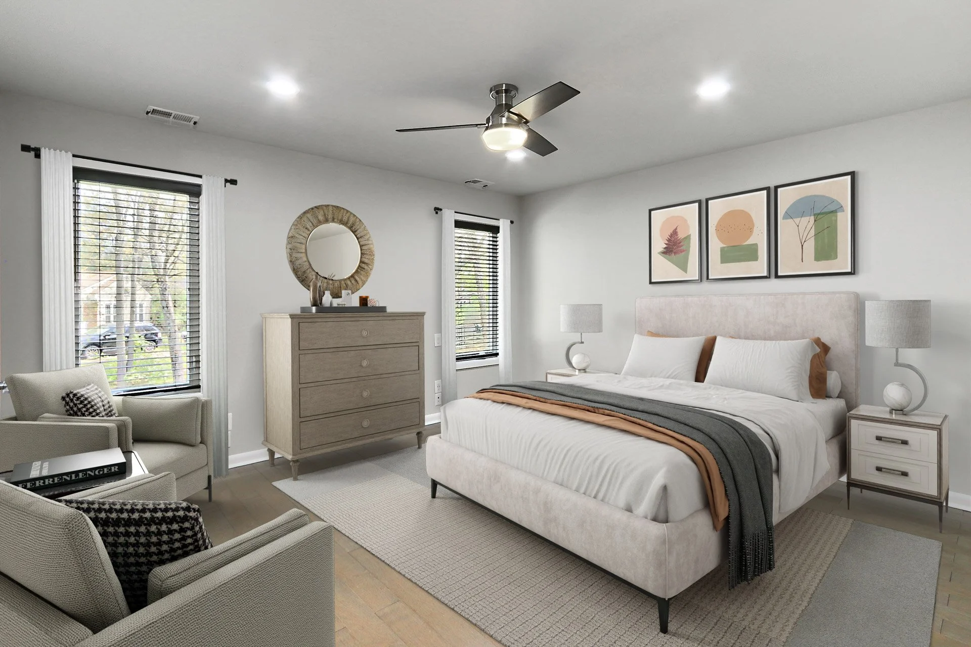 A modern bedroom with a king-size bed, two nightstands with lamps, a dresser with a mirror, a cozy armchair, and a ceiling fan, featuring natural light from two windows and minimalist artwork on the wall.
