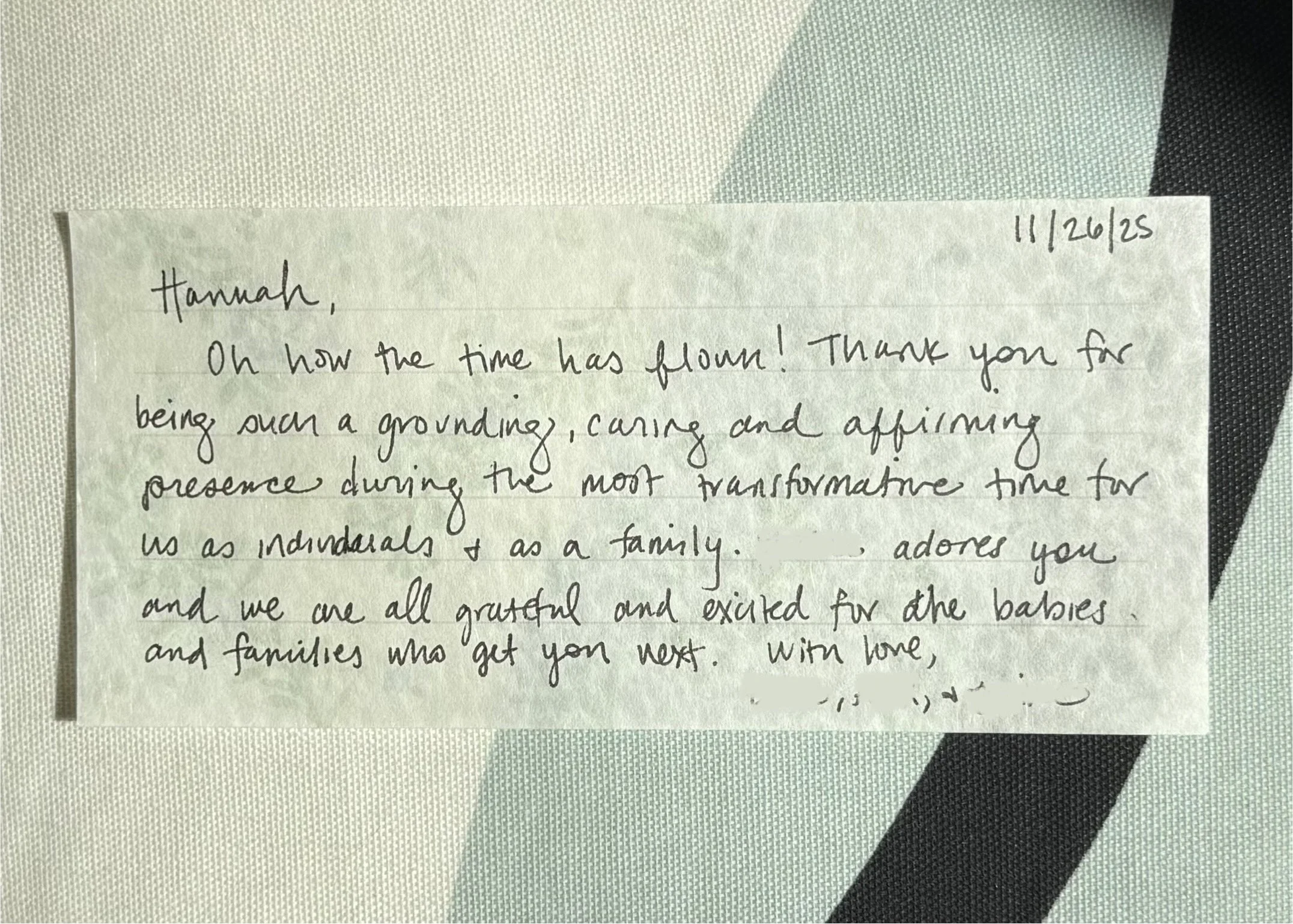 A handwritten note on a piece of paper with a date in the top right corner, placed on a textured surface with black and white sections.