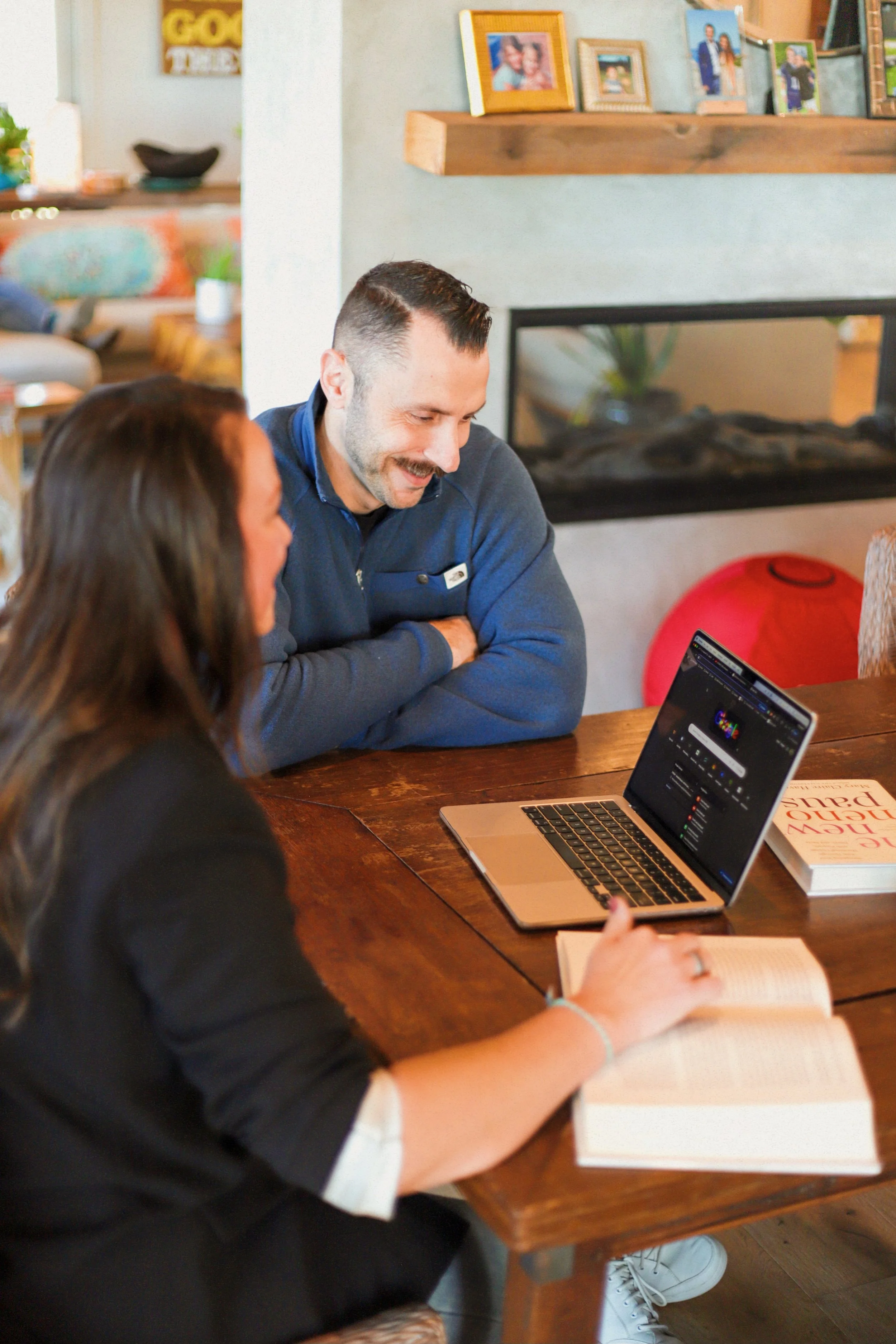 People participating in an outdoor group workout, stretching and warming up in a parking lot, with trees and a fence in the background, as the sun sets.