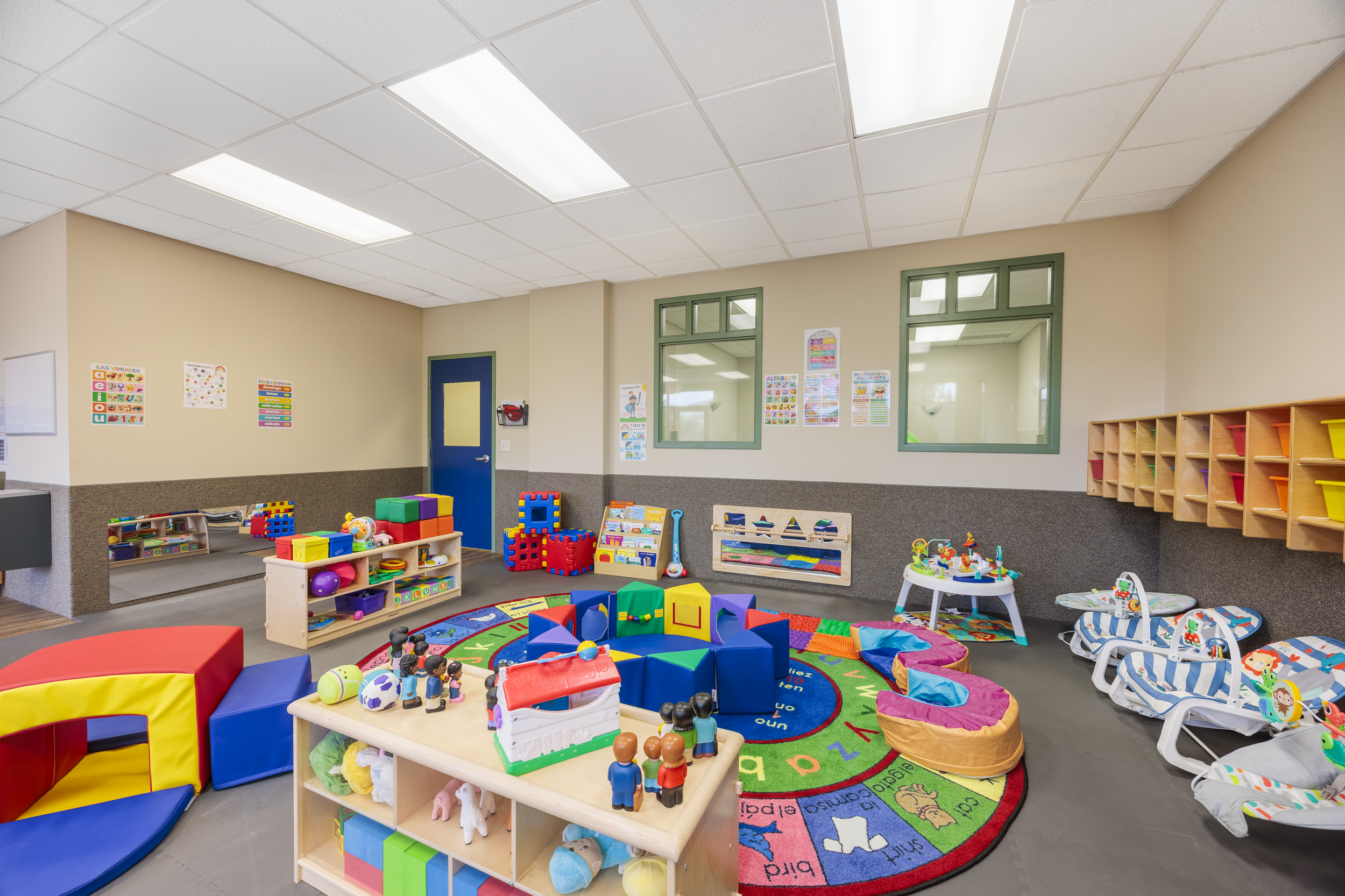An indoor children's playroom with soft mats, toys, and colorful equipment for kids.
