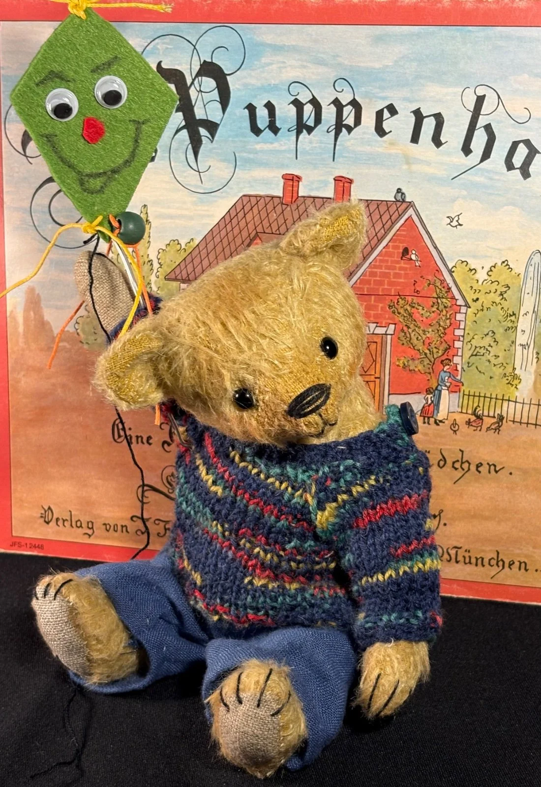 Nahaufnahme von Teddybär Max' Gesicht mit Drachen am oberen Bildrand