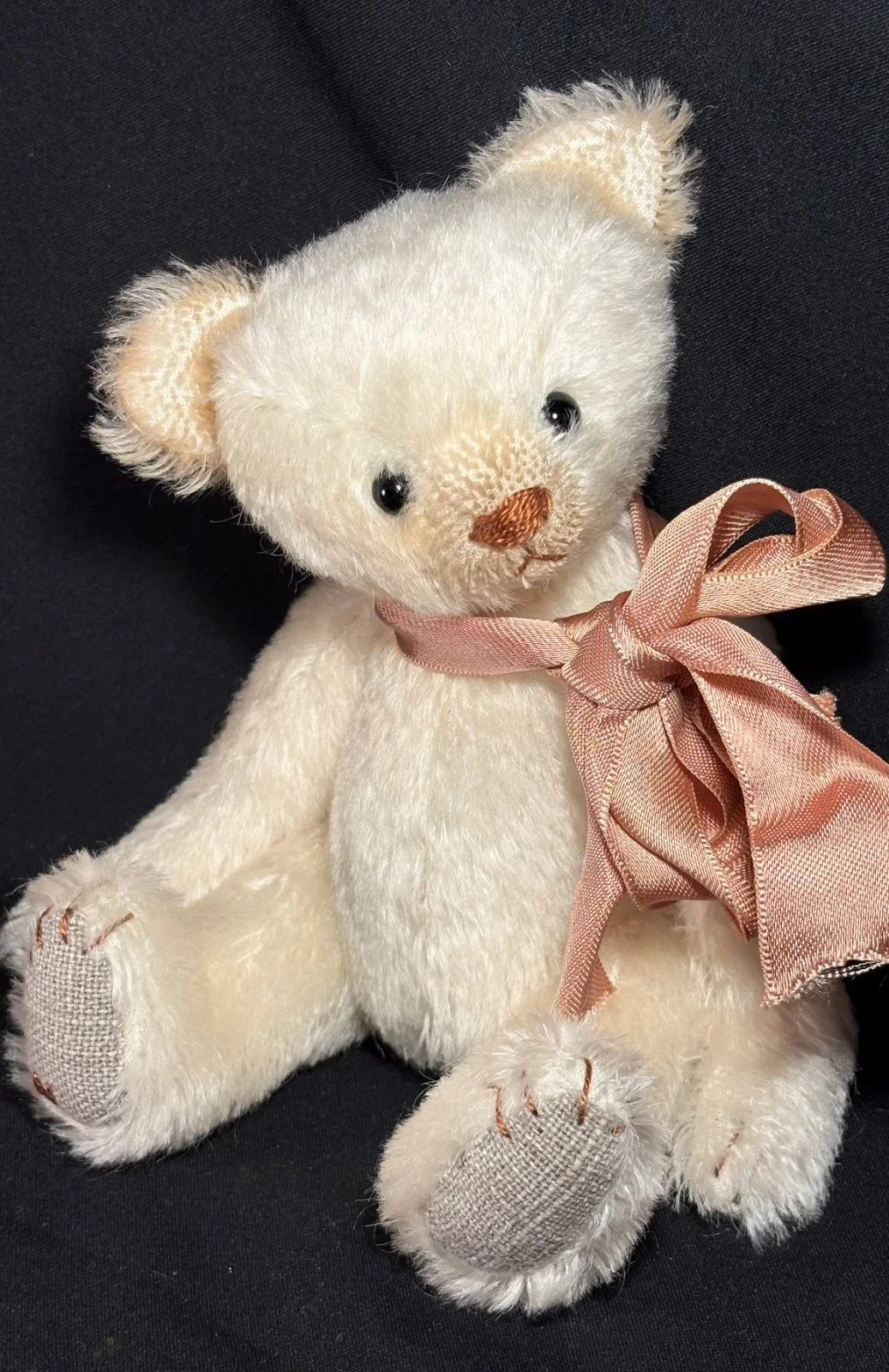 Teddybär sitzend von vorn, Nahaufnahme von Gesicht und Schleife