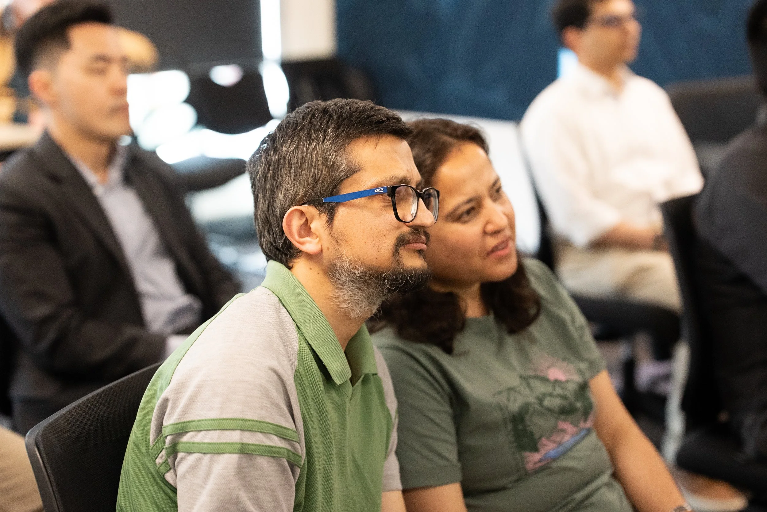 People attending a conference or seminar, sitting and listening attentively.