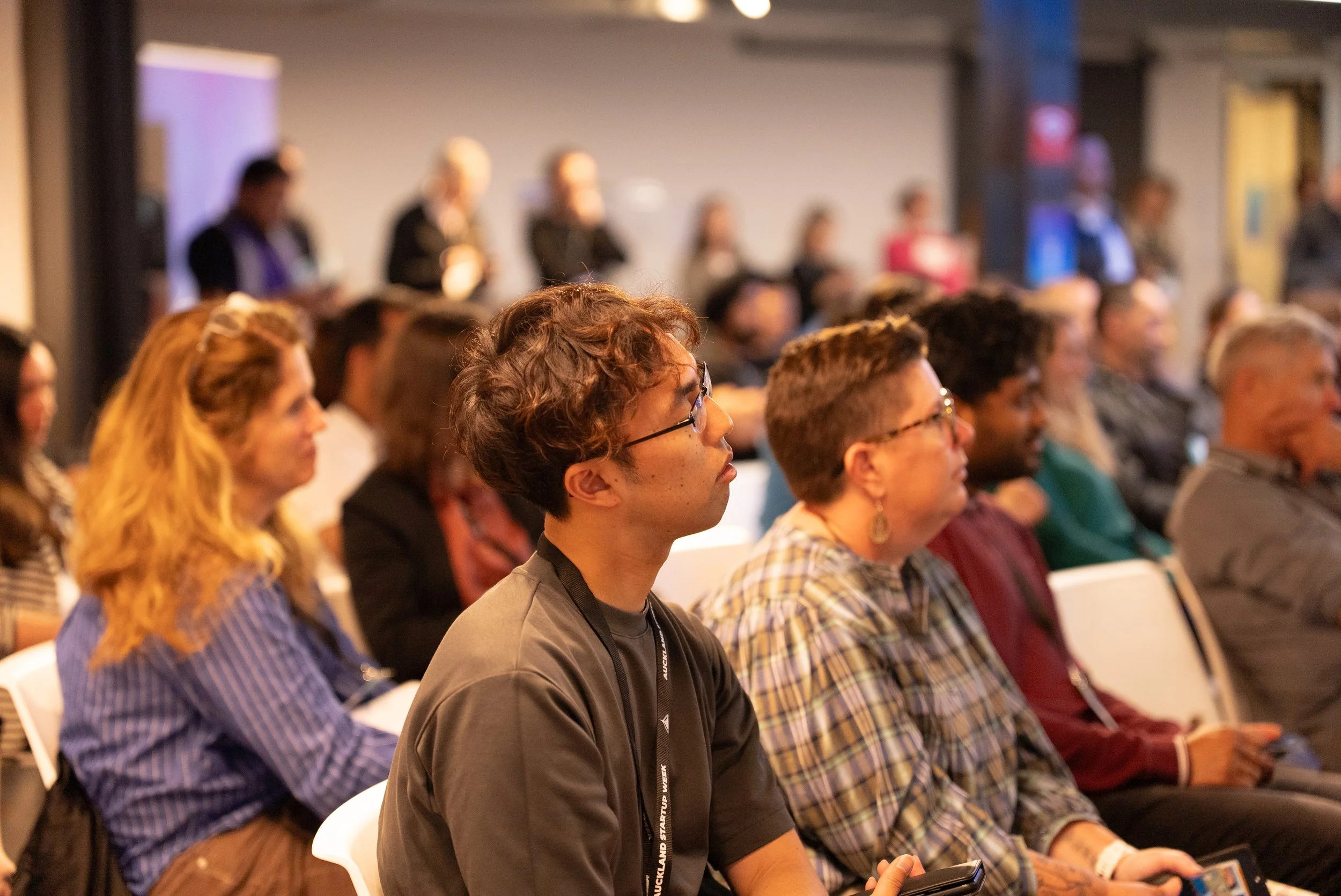 Audience members sitting and listening attentively at a conference or event.