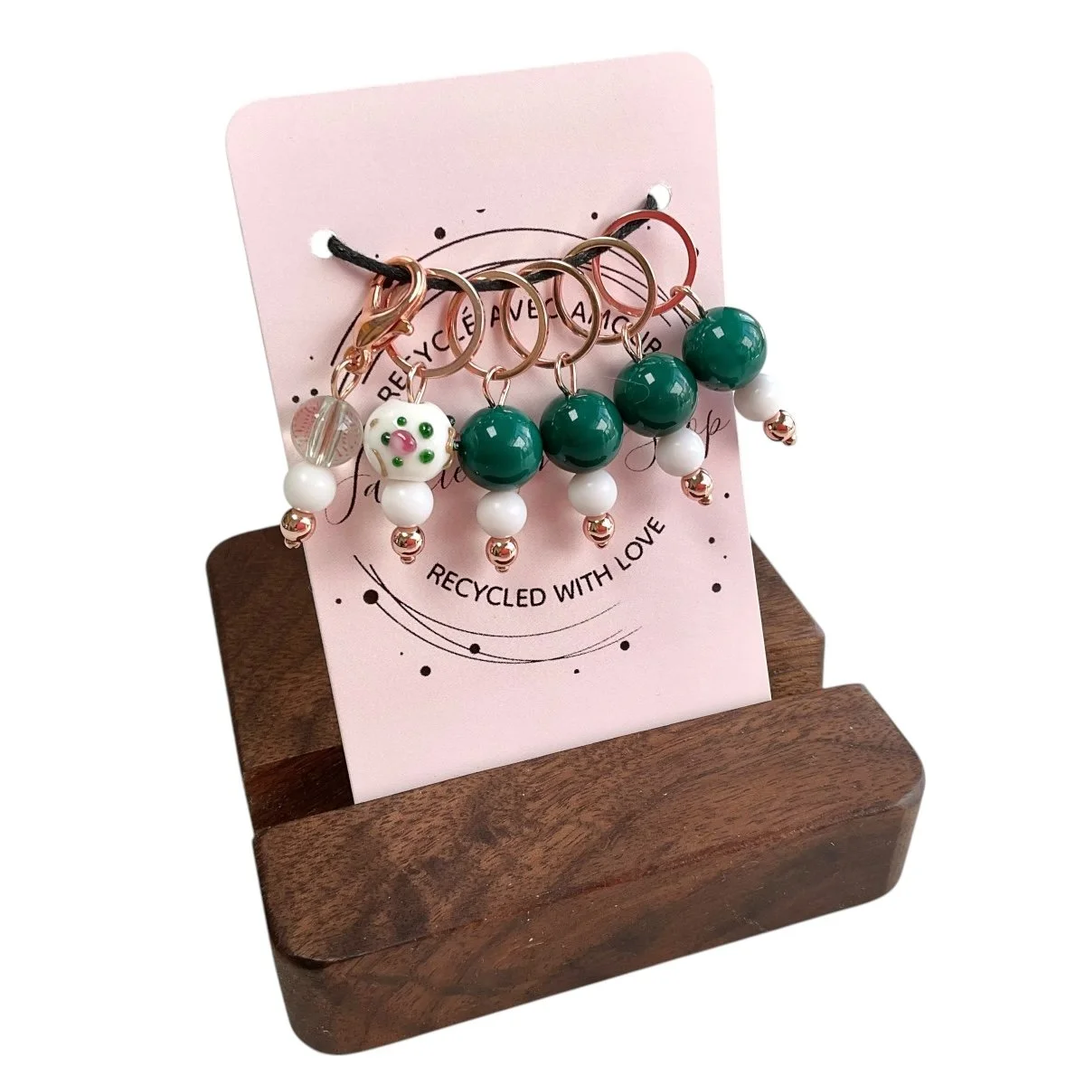 Ensemble de marqueurs de mailles avec perles vertes et blanches, support en bois, carte rose marquée "Recycled with Love".