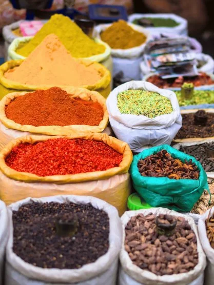 Various colorful spices displayed in sacks at a market