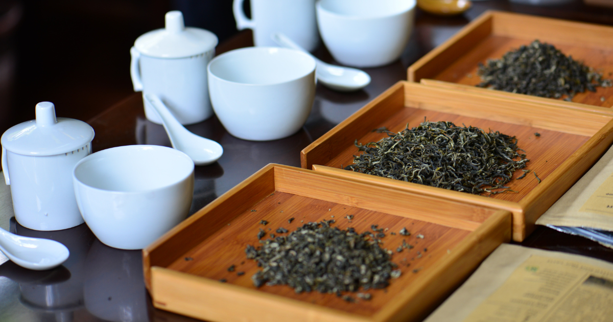 Trays of loose leaf tea with tasting cups at the Munnar Tea Museum