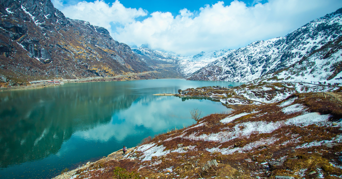 The turquoise waters of Tsomgo Lake surrounded by snow-dusted mountains in East Sikkim
