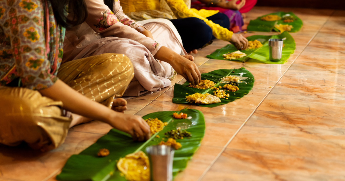 A full South Indian meal served on a banana leaf with rice, sambar, vegetable dishes, pickles and fried banana chips